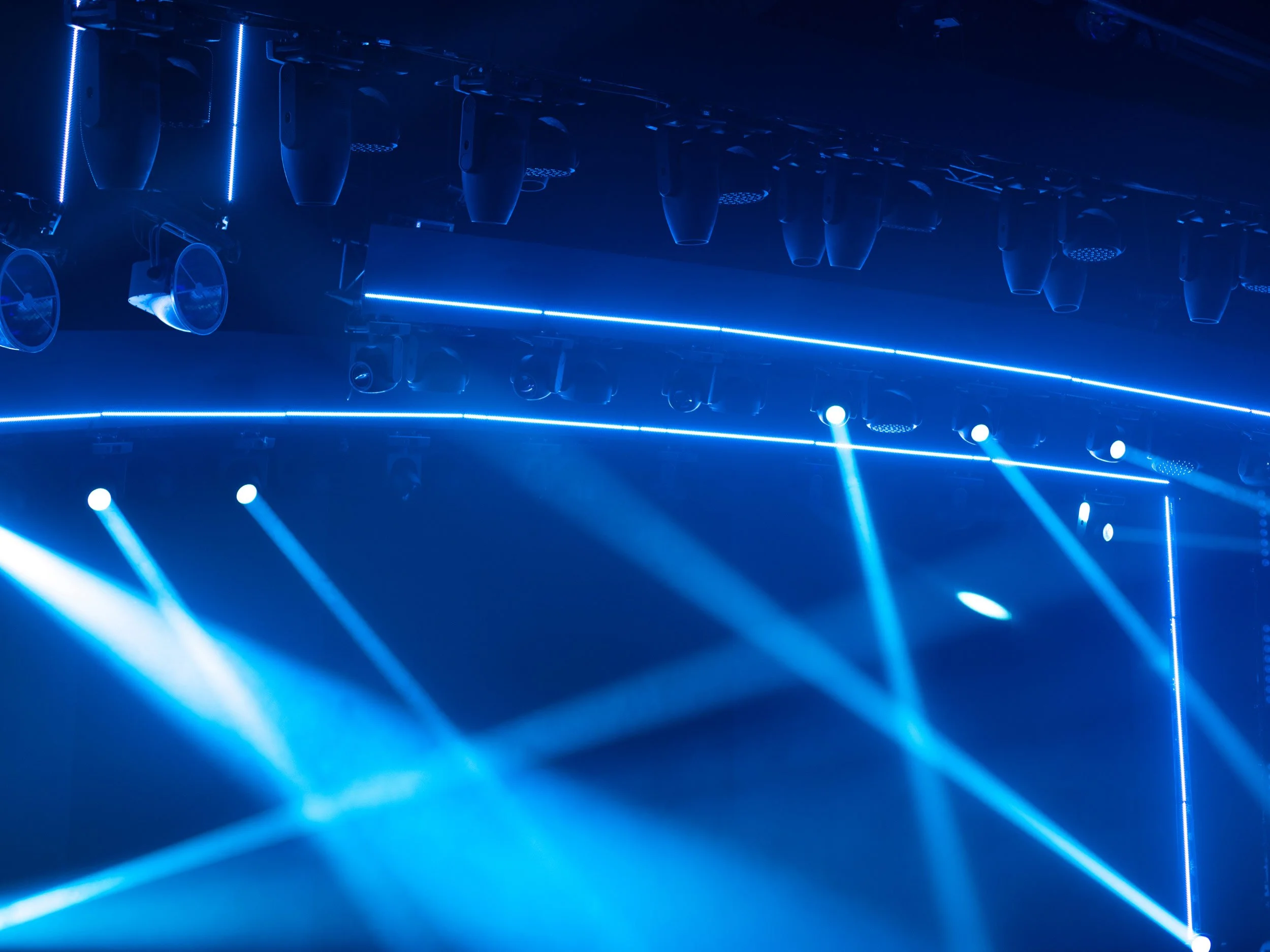 Stage lighting with blue-coloured spotlights and fog machine smoke.