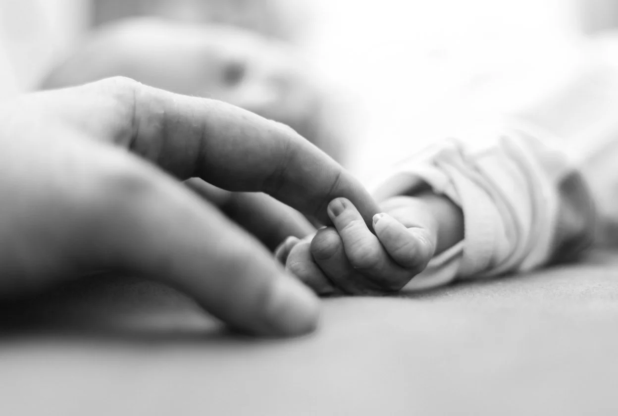 Family and parenting support (black & white photo of a family holding hands)