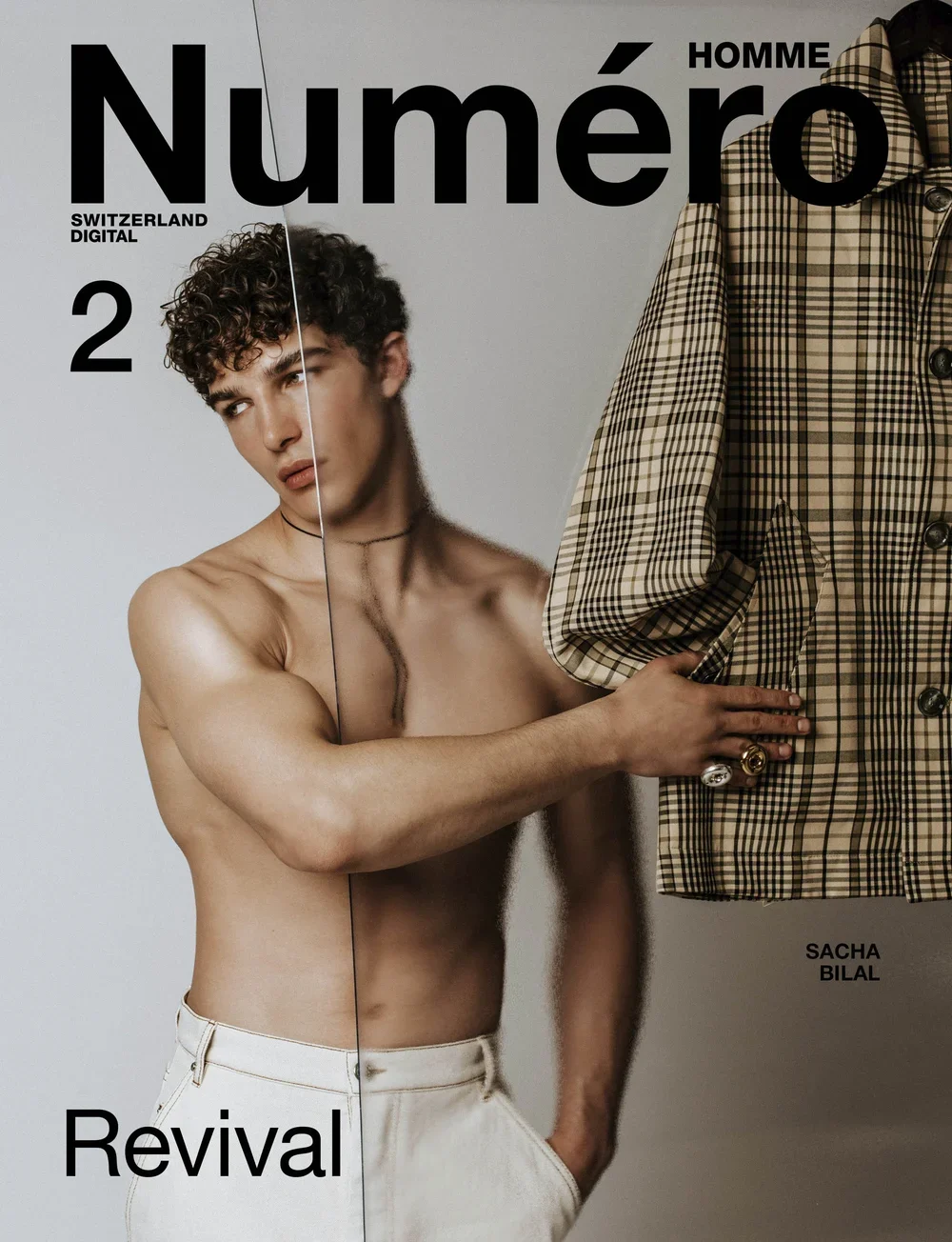 Cover of Numéro Homme magazine featuring a shirtless male model with curly hair, holding a patterned coat, with the title "Numéro Homme Revival" and the name Sacha Bilal on the cover.