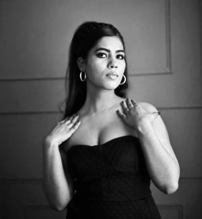 Photo of a woman wearing a dramatic black dress and cat eye makeup