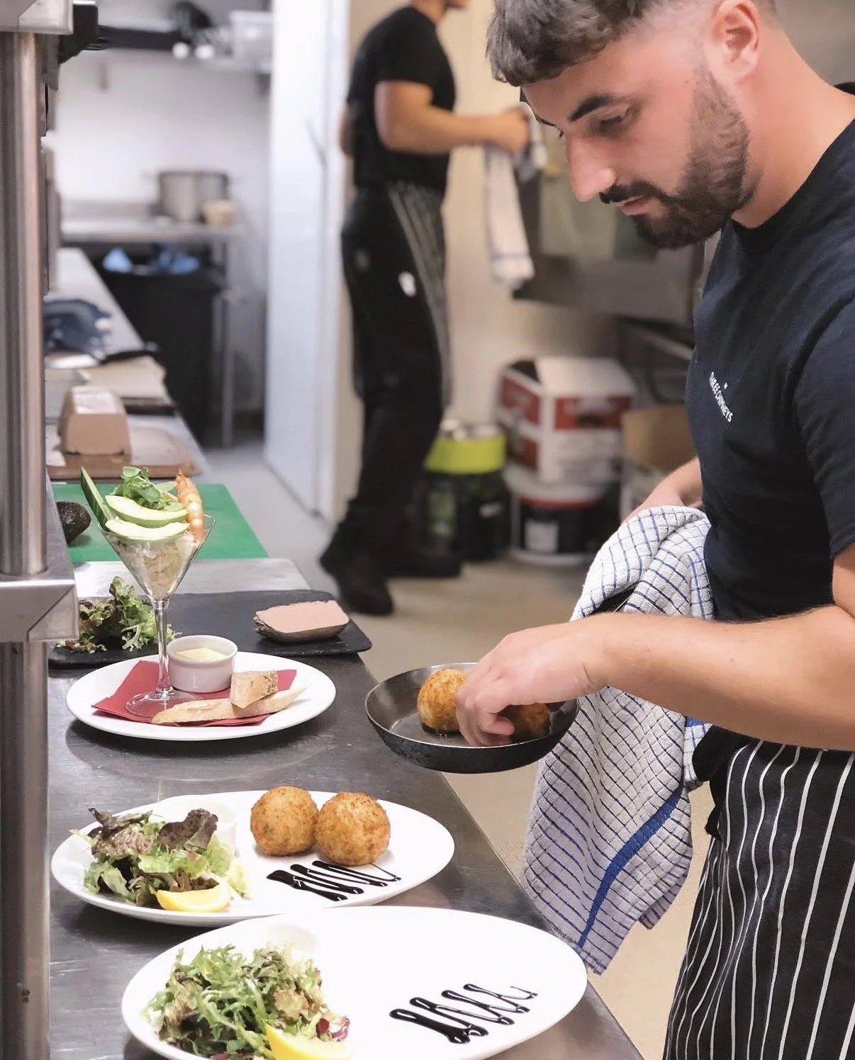 Chef plating freshly prepared dishes during a busy kitchen service at The Three Chimneys.