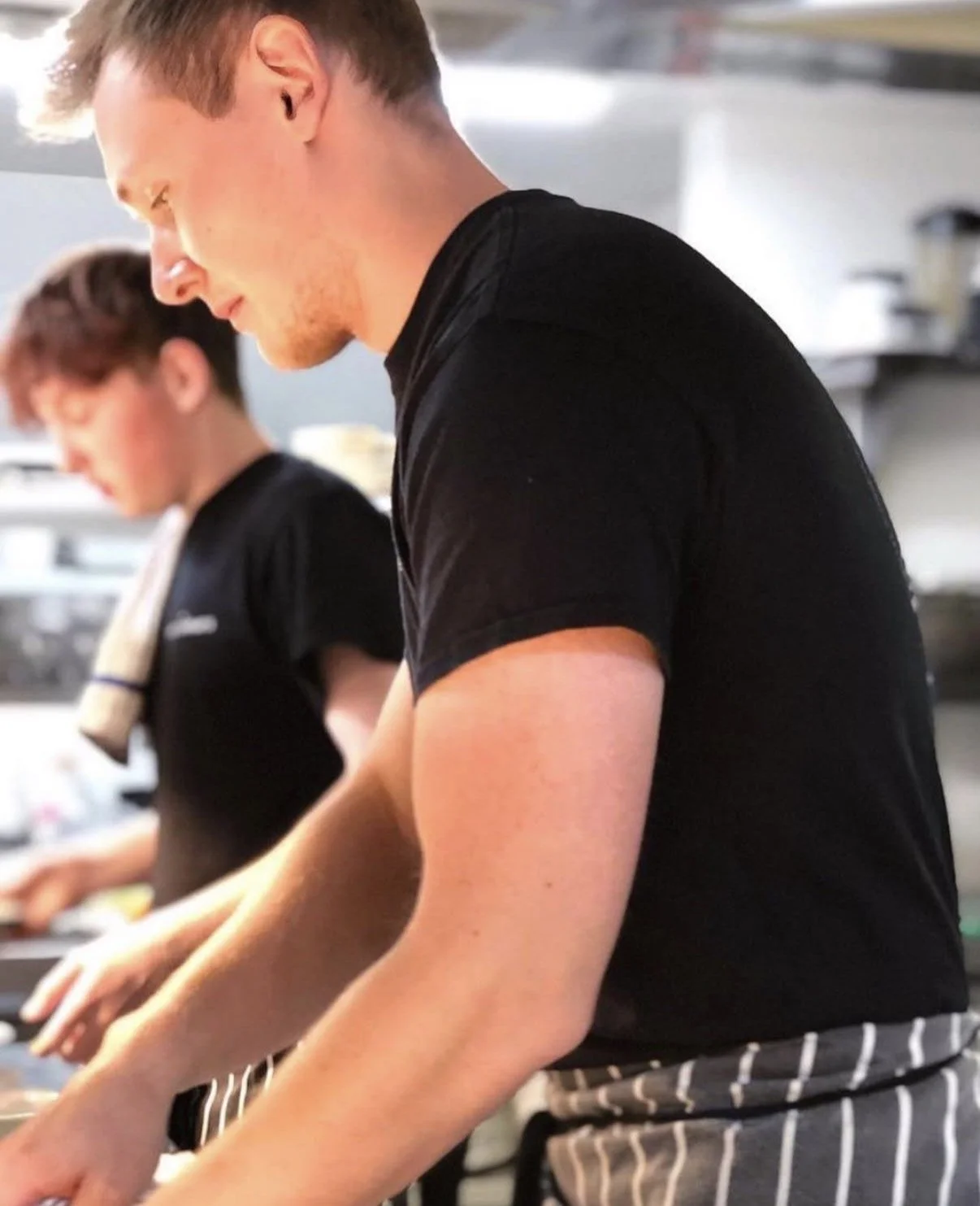 Kitchen team member preparing ingredients and working during food service at The Three Chimneys.