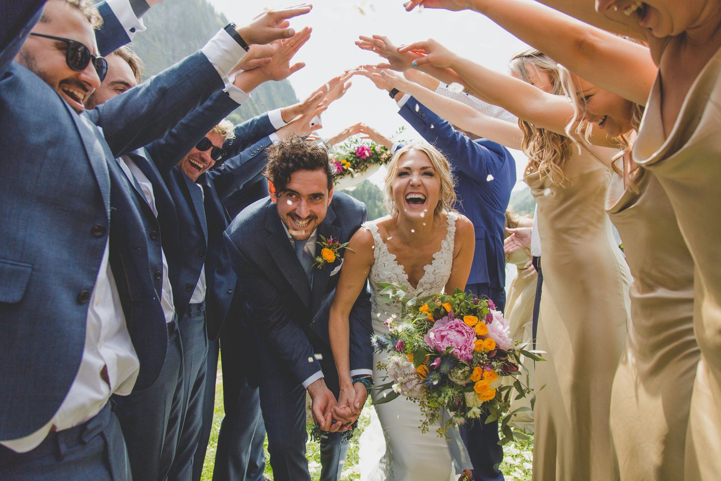 bride and groom going through confetti tunnel at their destination wedding in france