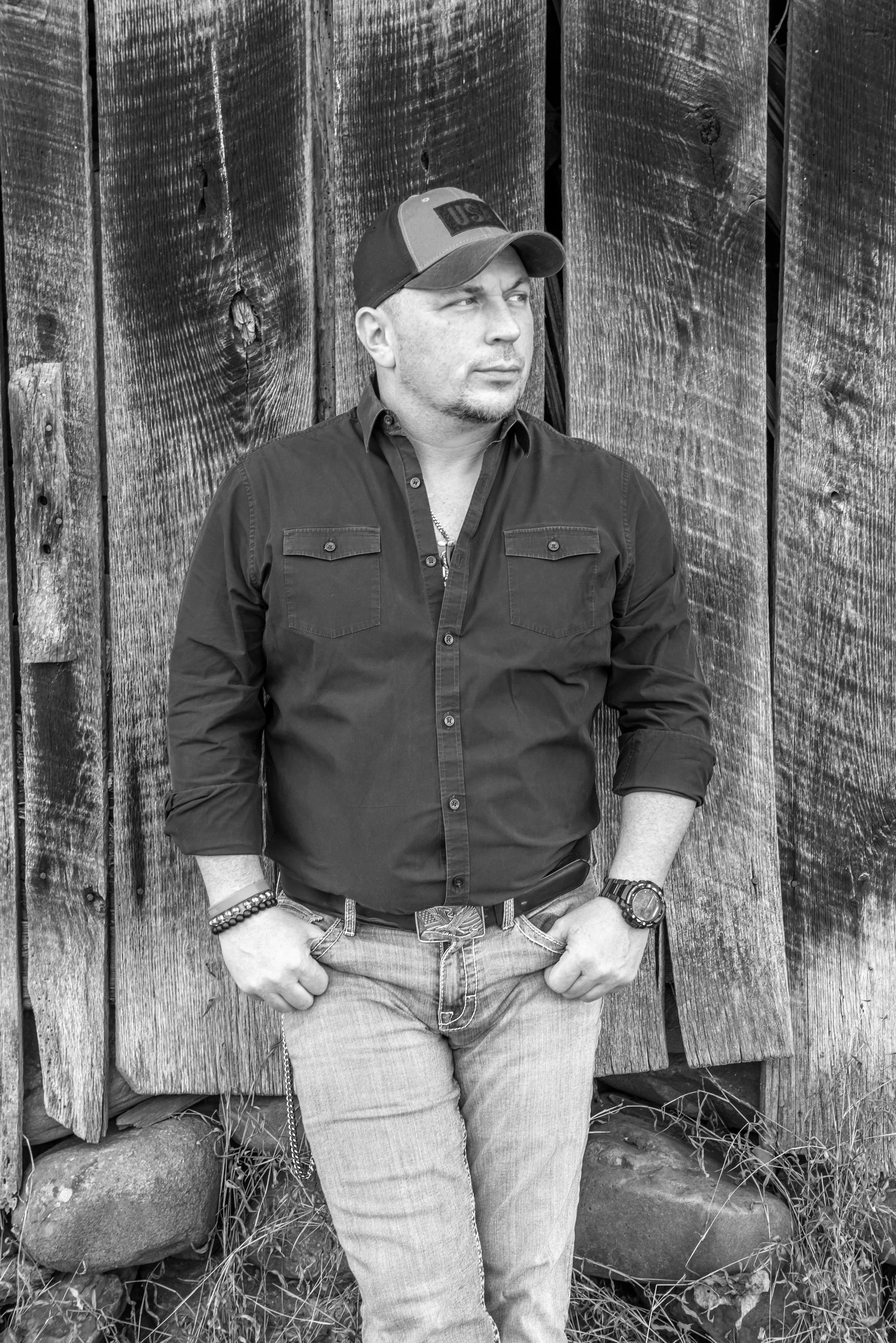 Jay Dee country singer standing in front of rustic barn in Tennessee