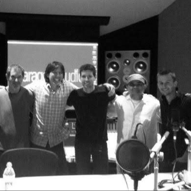 Micah Peacock with other musicians and engineers in a recording studio