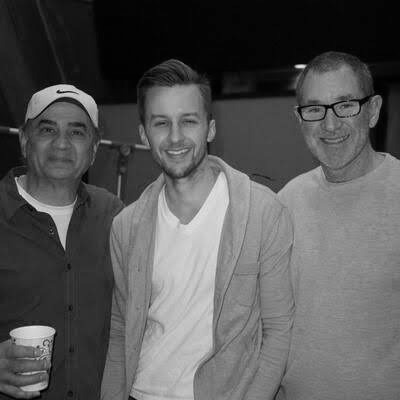 Micah Peacock with music producers in a recording studio