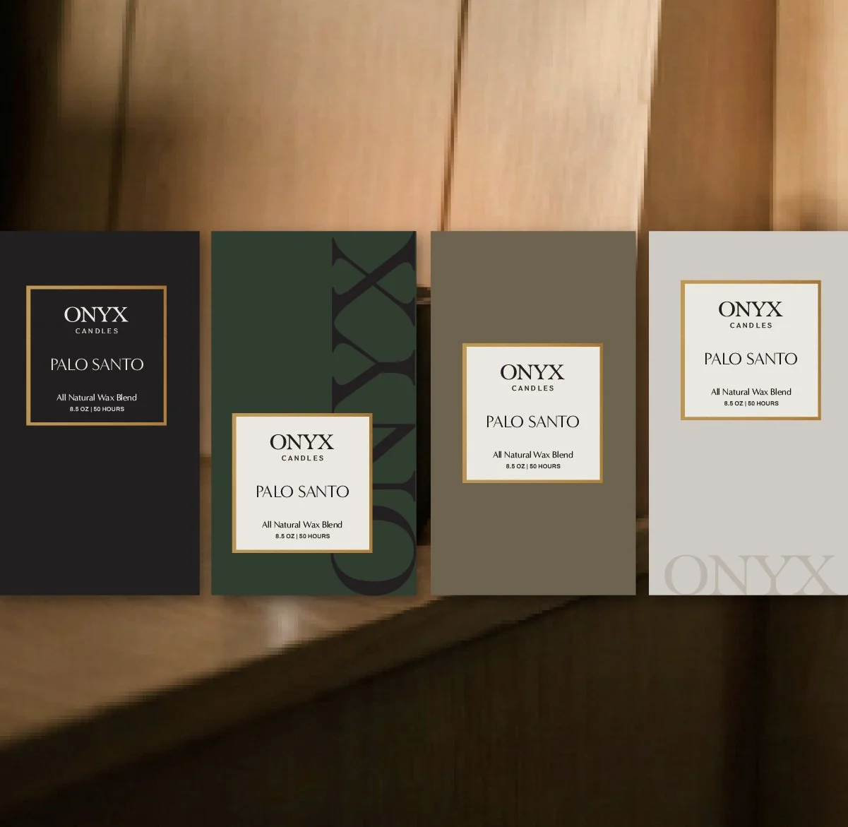 Four boxes of Onyx Palo Santo candles with different packaging designs placed on a wooden surface.
