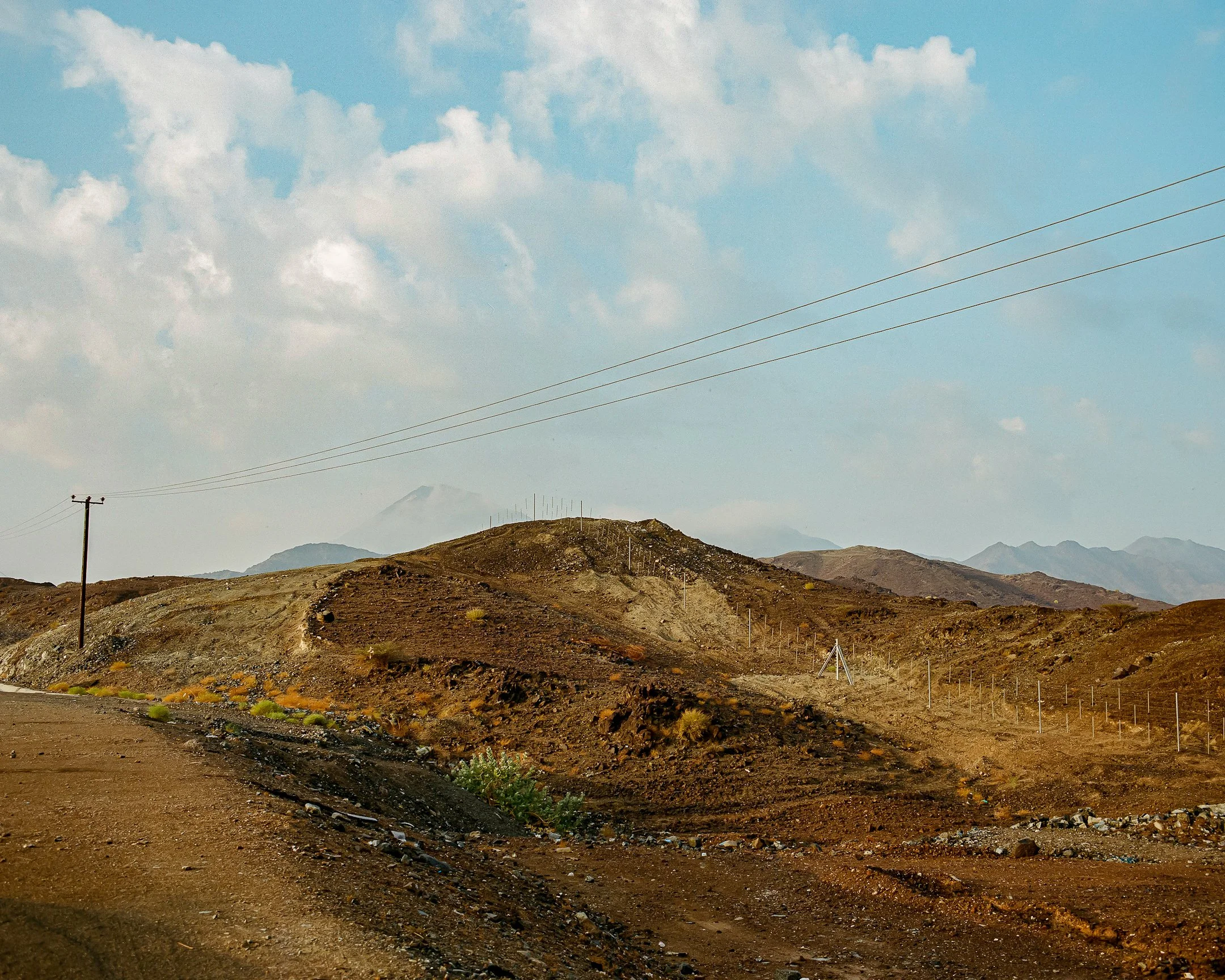 Dubai - Hatta road - Old power grid pole and a barbed wire fence.