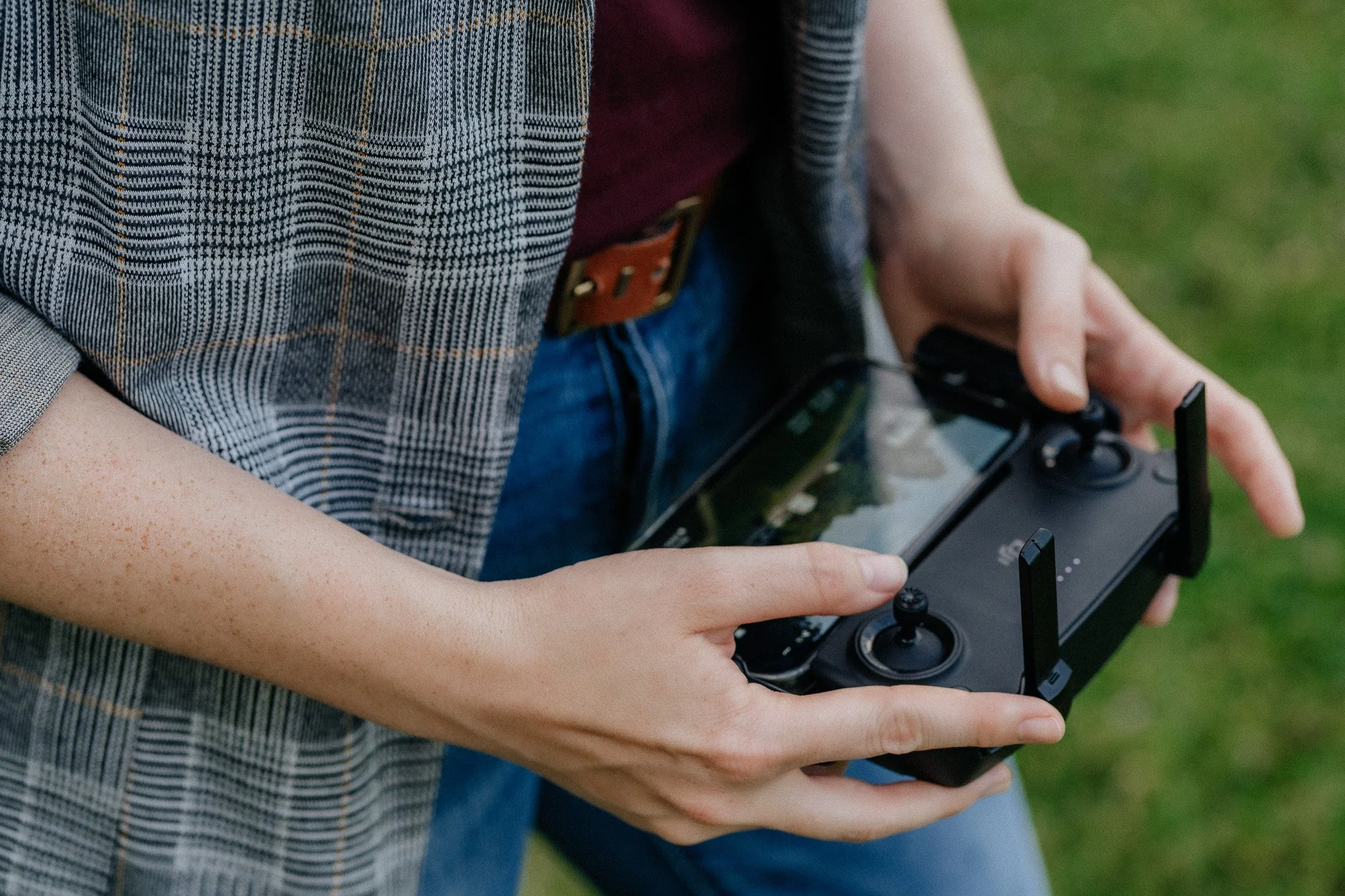 Person holding a drone controller outdoors.