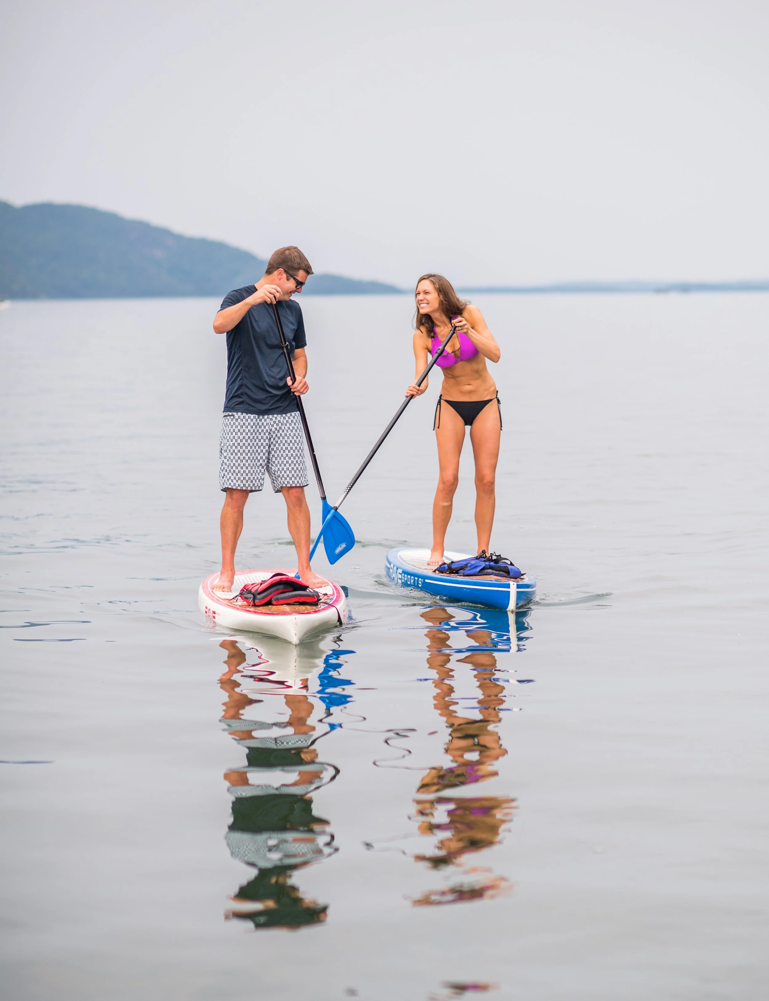 lifestyle photo of man and woman on stand up paddleboards on lake champlain vermont