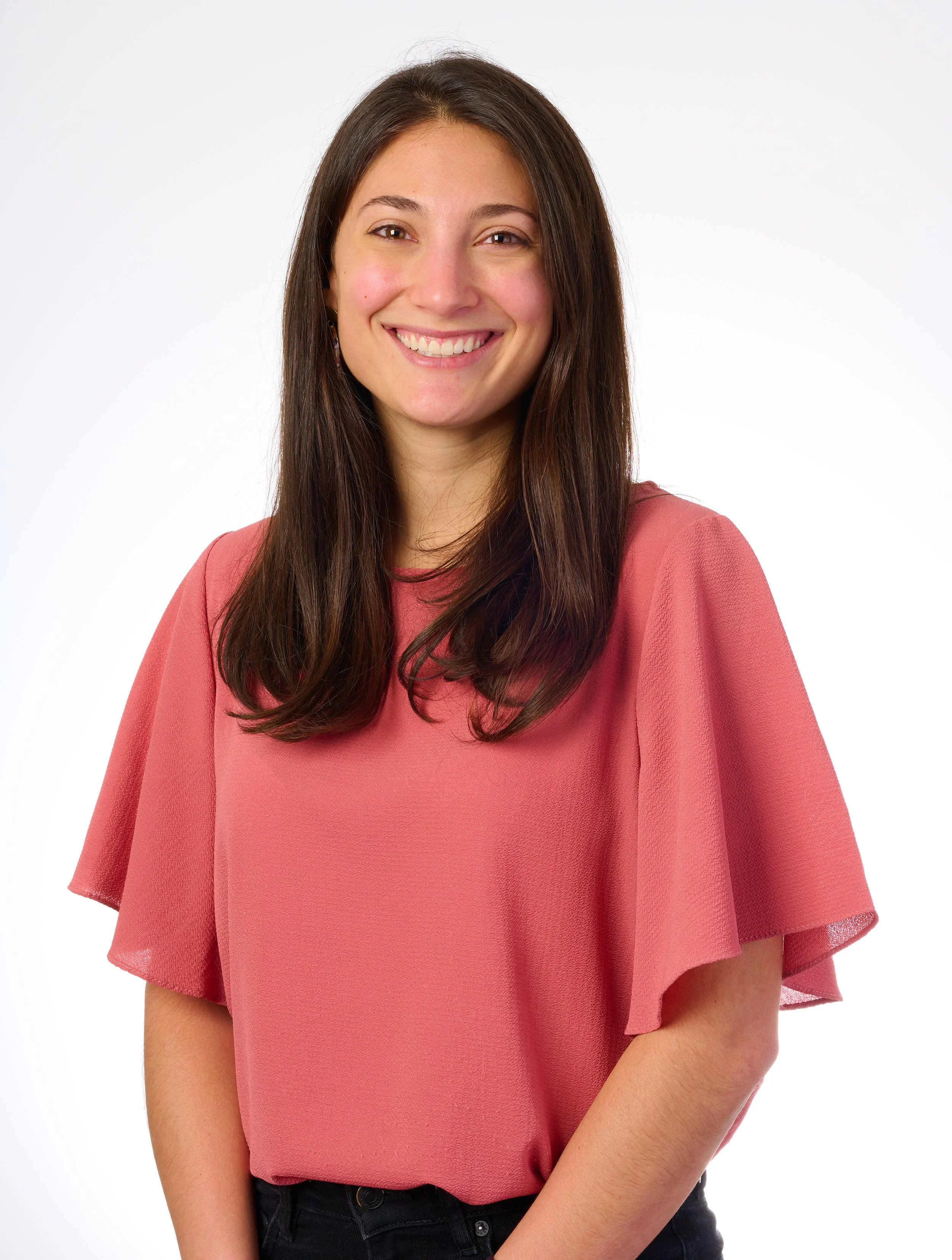 headshot of woman in a salmon colored blouse in front of  white background taken in Burlington vermont photo studio