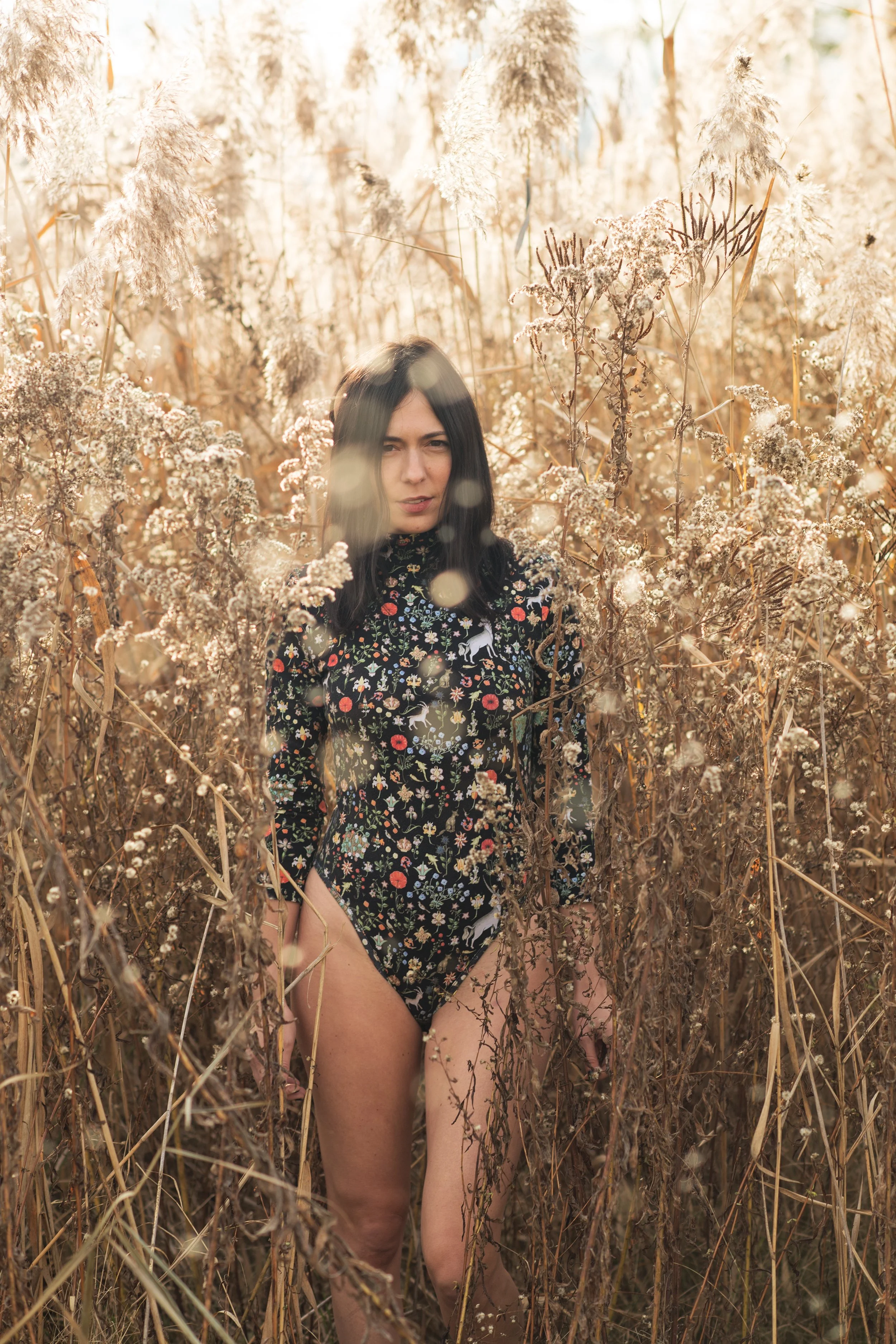 Burlington vermont fashion photographer michael heeney photographs amanda richer in a patterned black bodysuit while she stands in reeds 