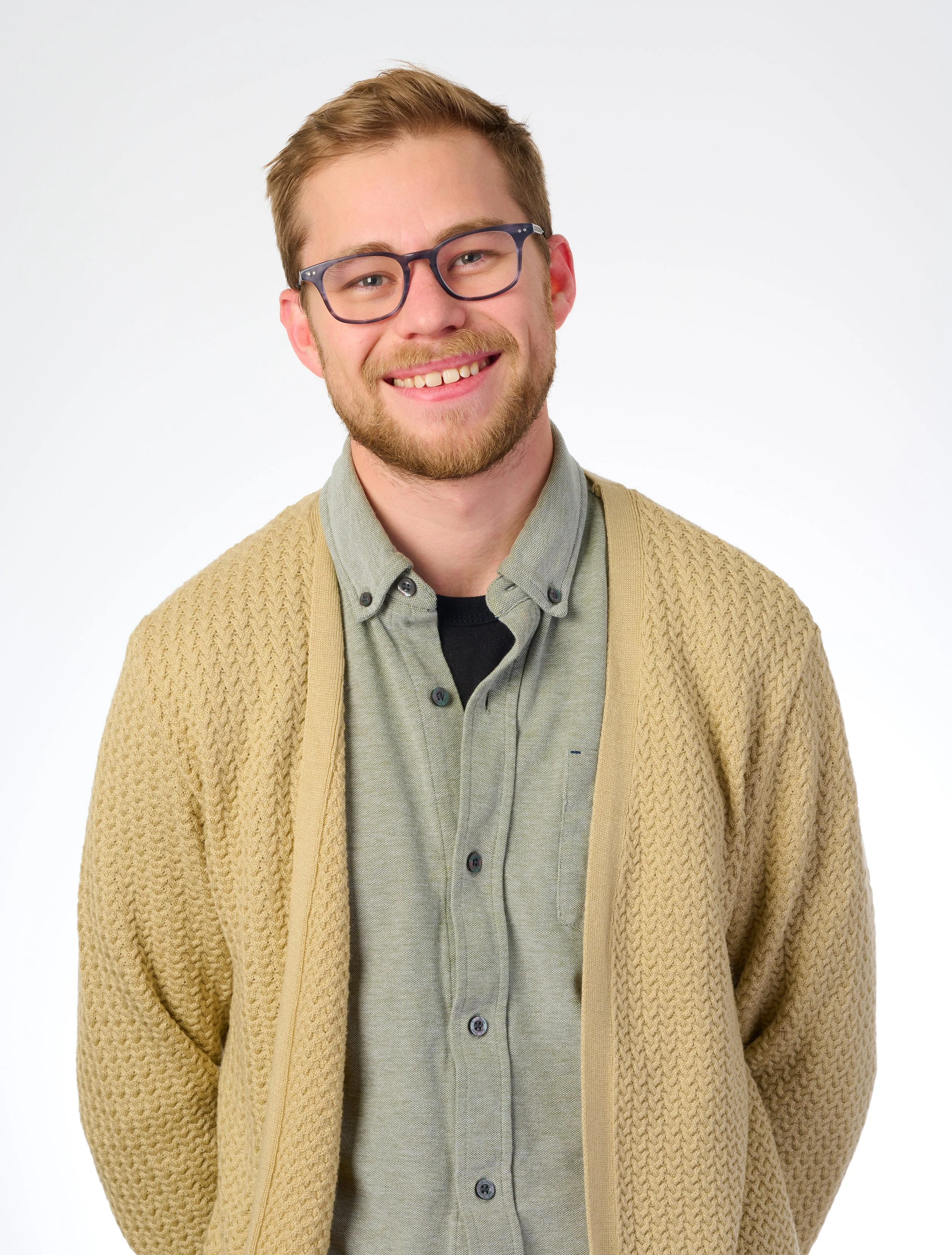 studio headshot of smiling vermont employee wearing a cardigan sweater