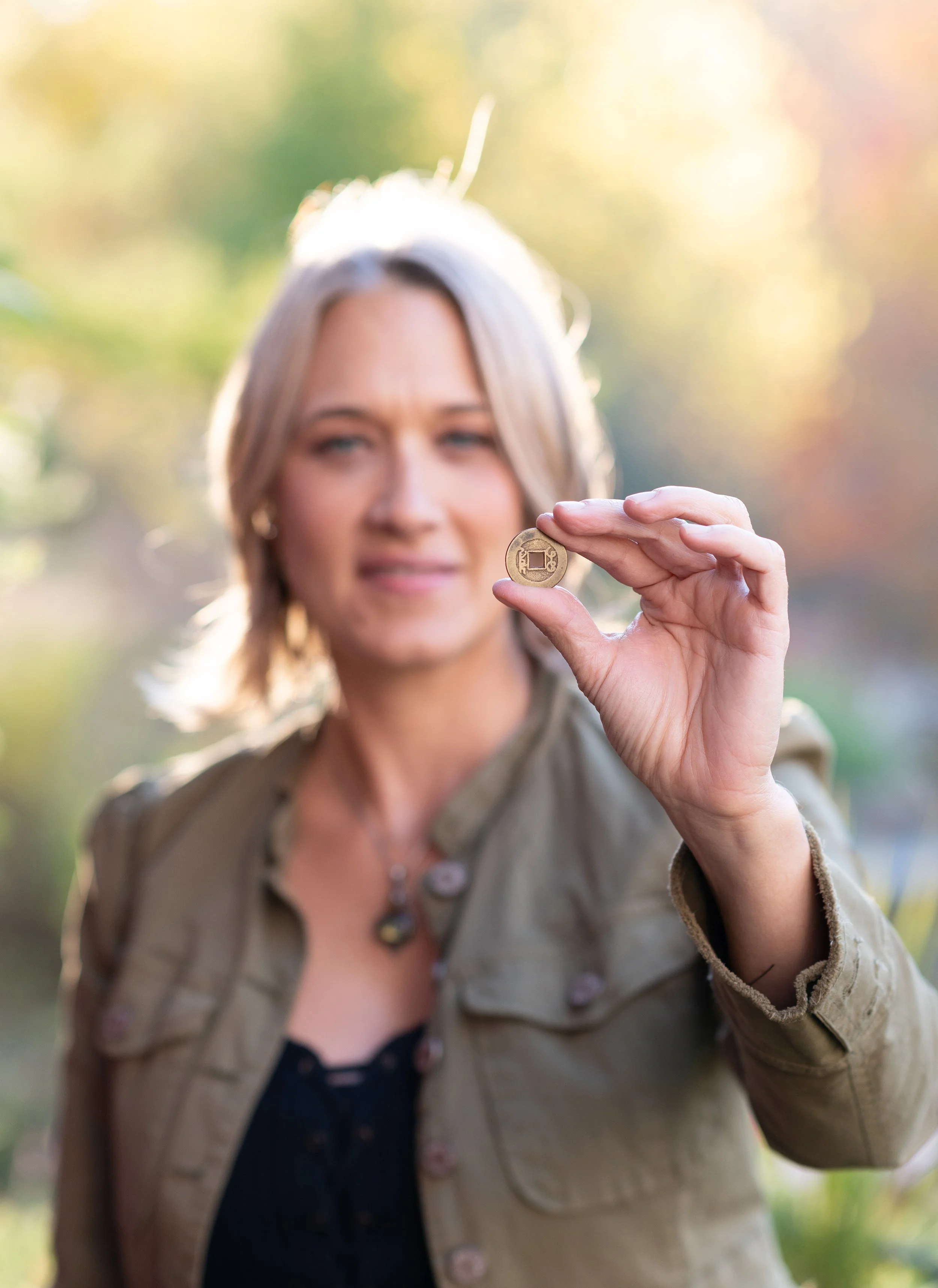 woman holds up a small coin
