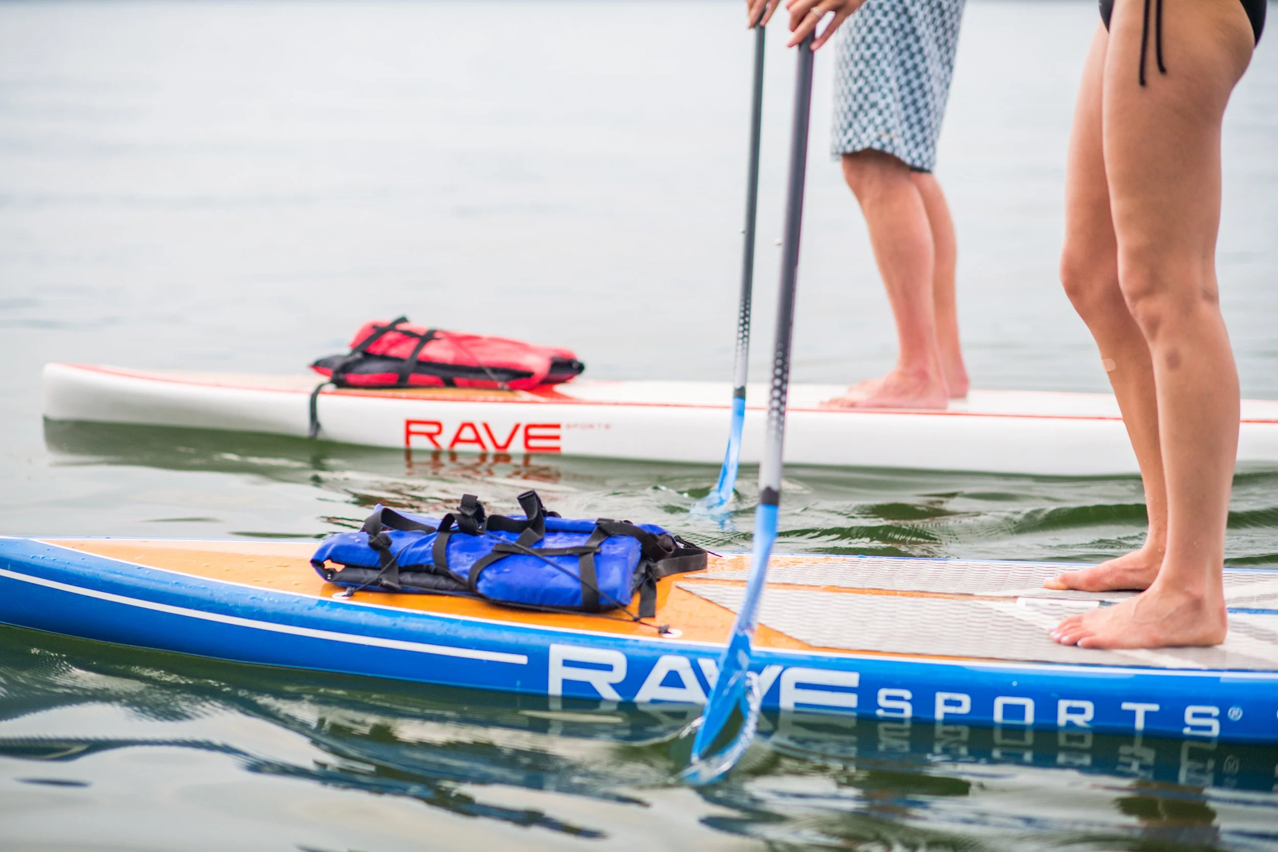 a man and womans legs on stand up paddleboards
