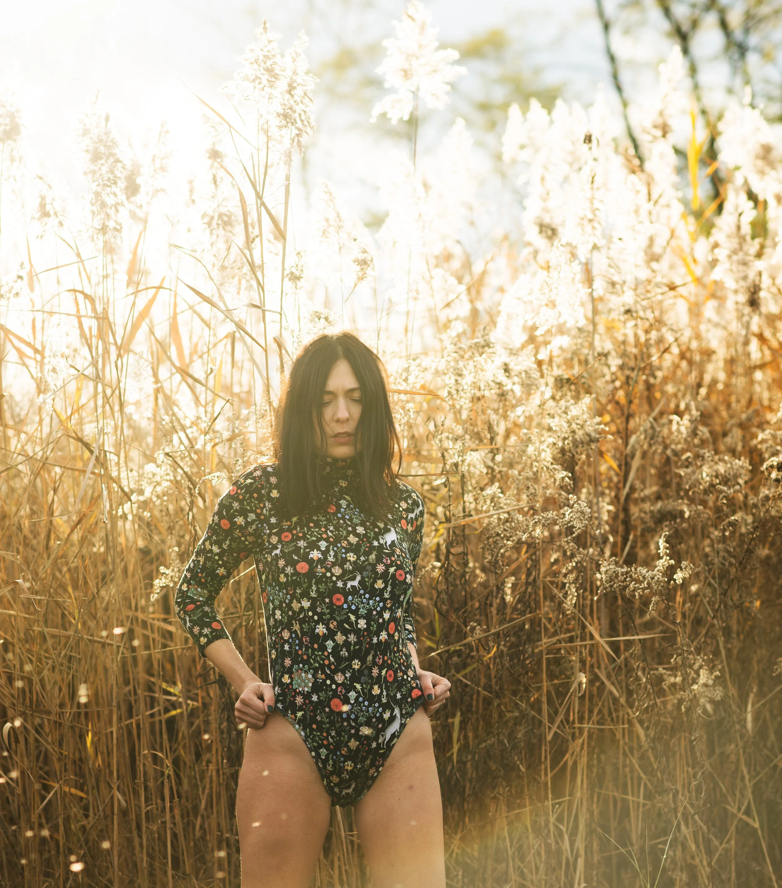 Burlington vermont fashion photography of  amanda richer in a patterned black bodysuit while she stands in reeds 