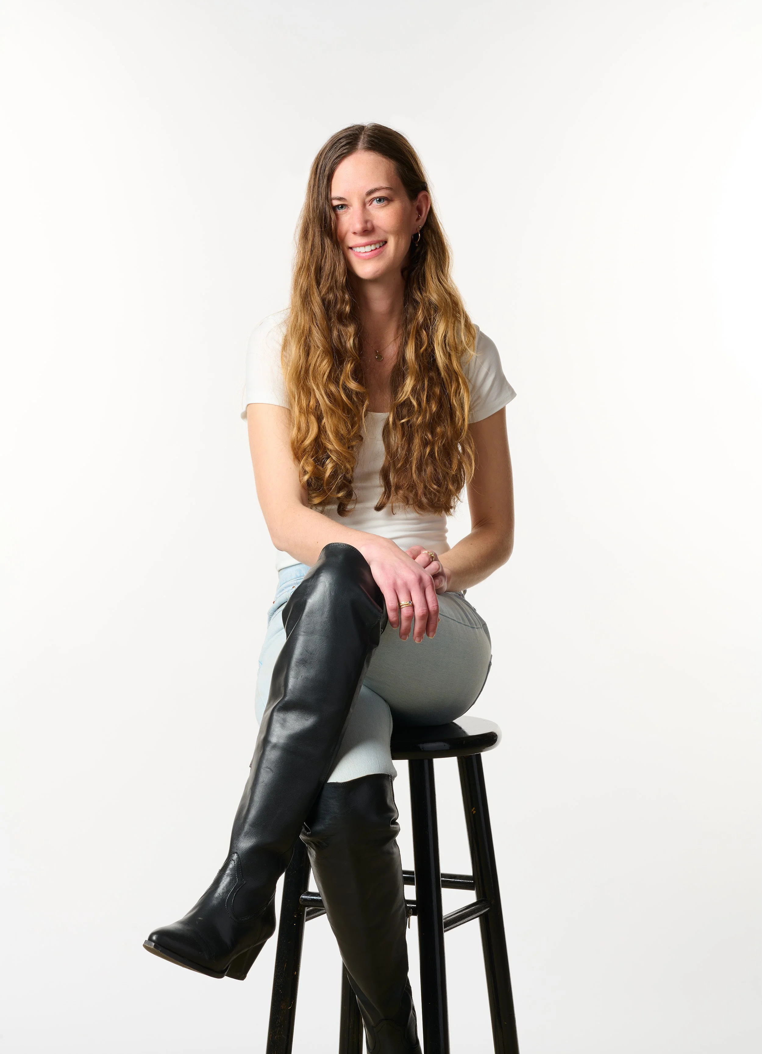 studio portrait of jeweler annika rundberg sitting on black stool