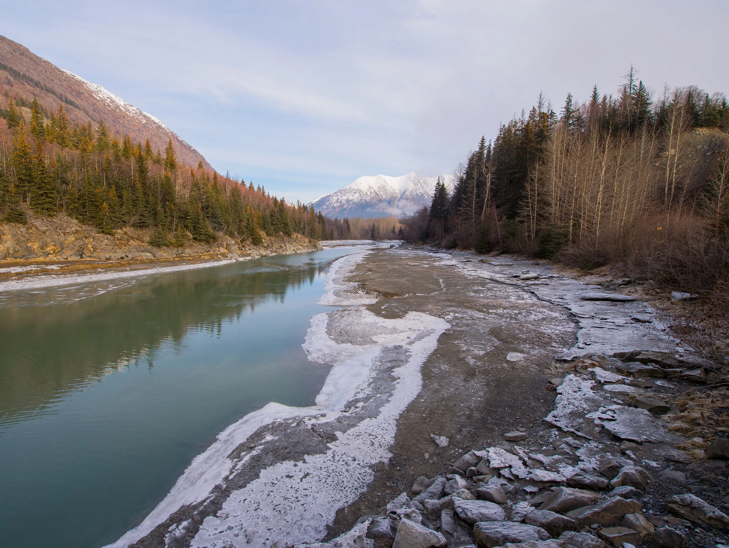 alaskan river with snowy peaks in the background