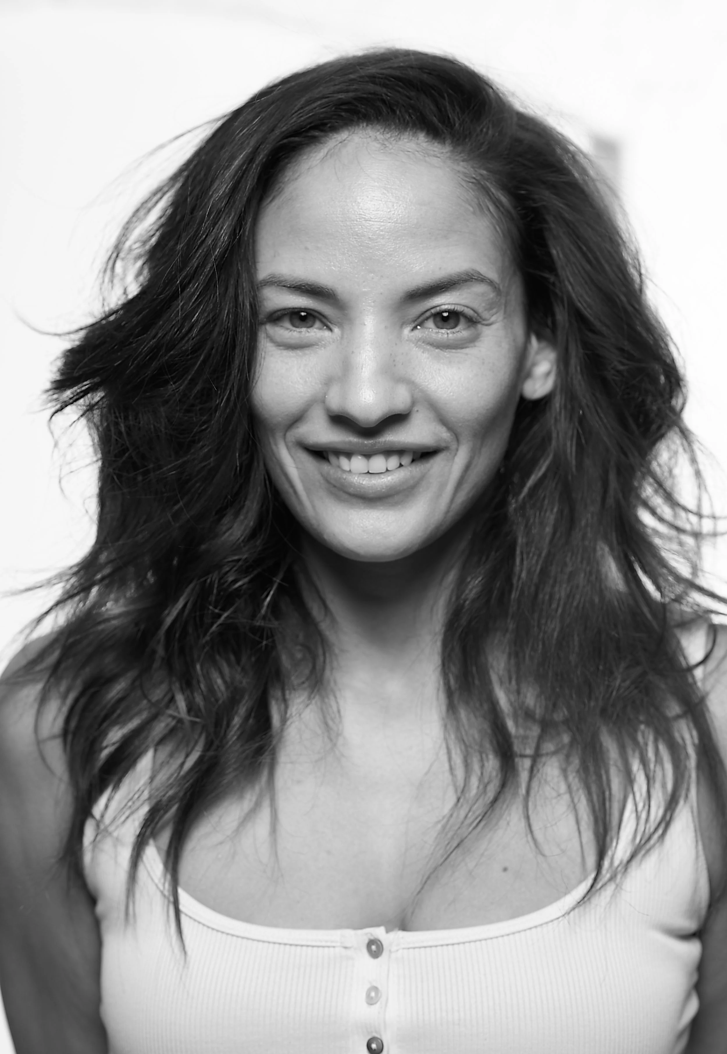 black and white portrait of a dark haired woman in a white tank top in a Burlington vermont photo studio