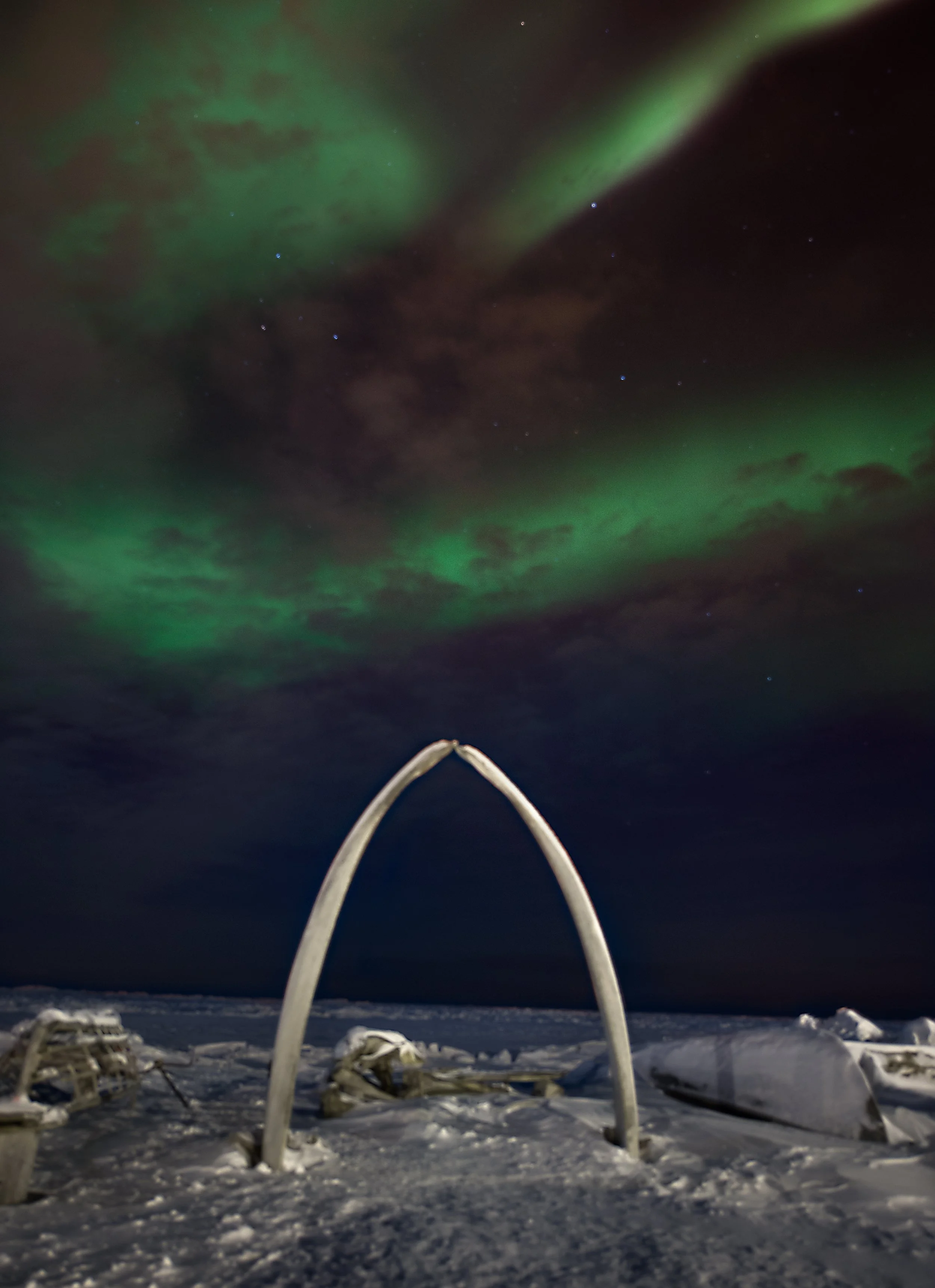 lost sailor memorial in barrow alaska made of two whale ribs with northern lights above in the sky