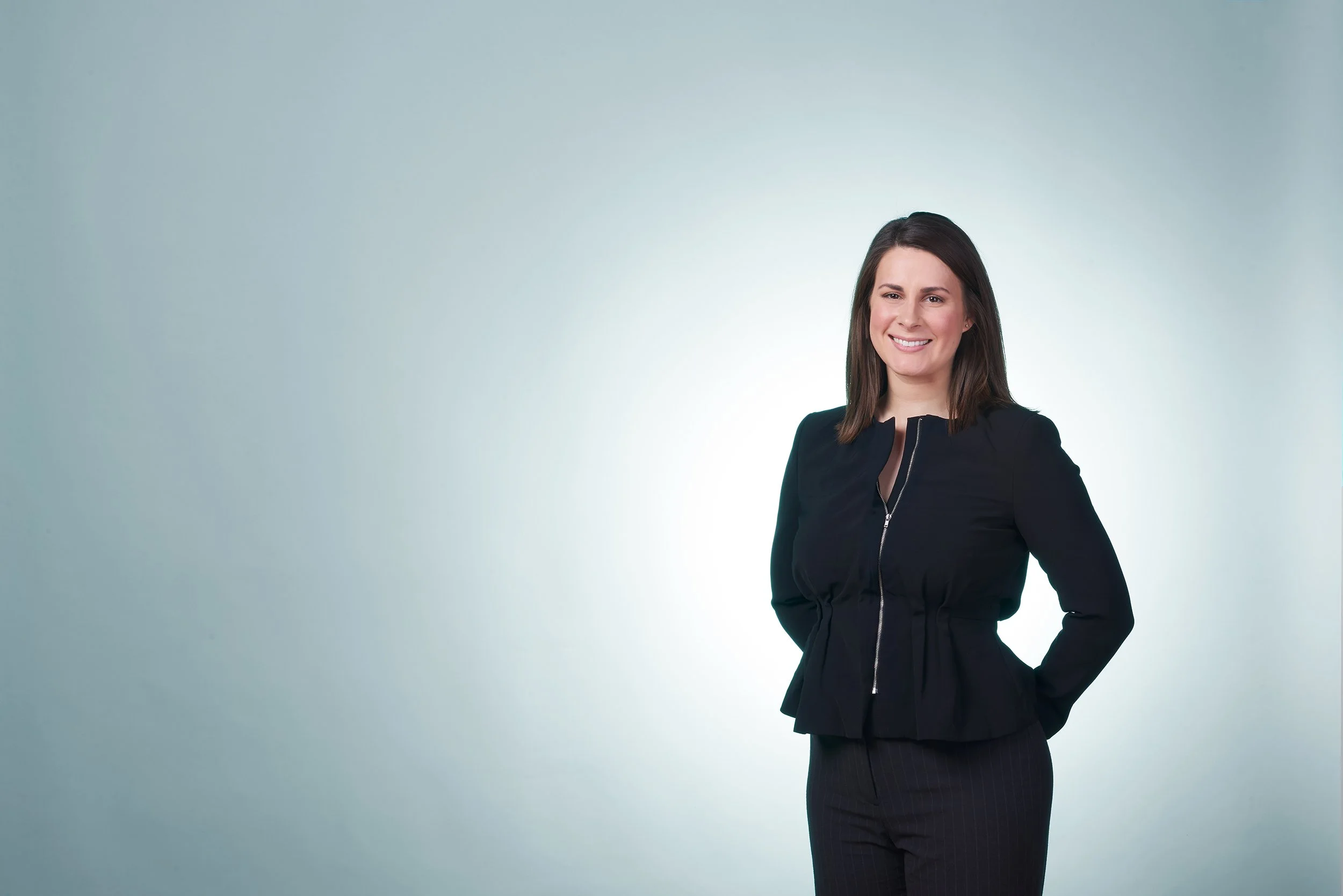 headshot of a professional woman in front of a blue background taken in Burlington vermont photo studio