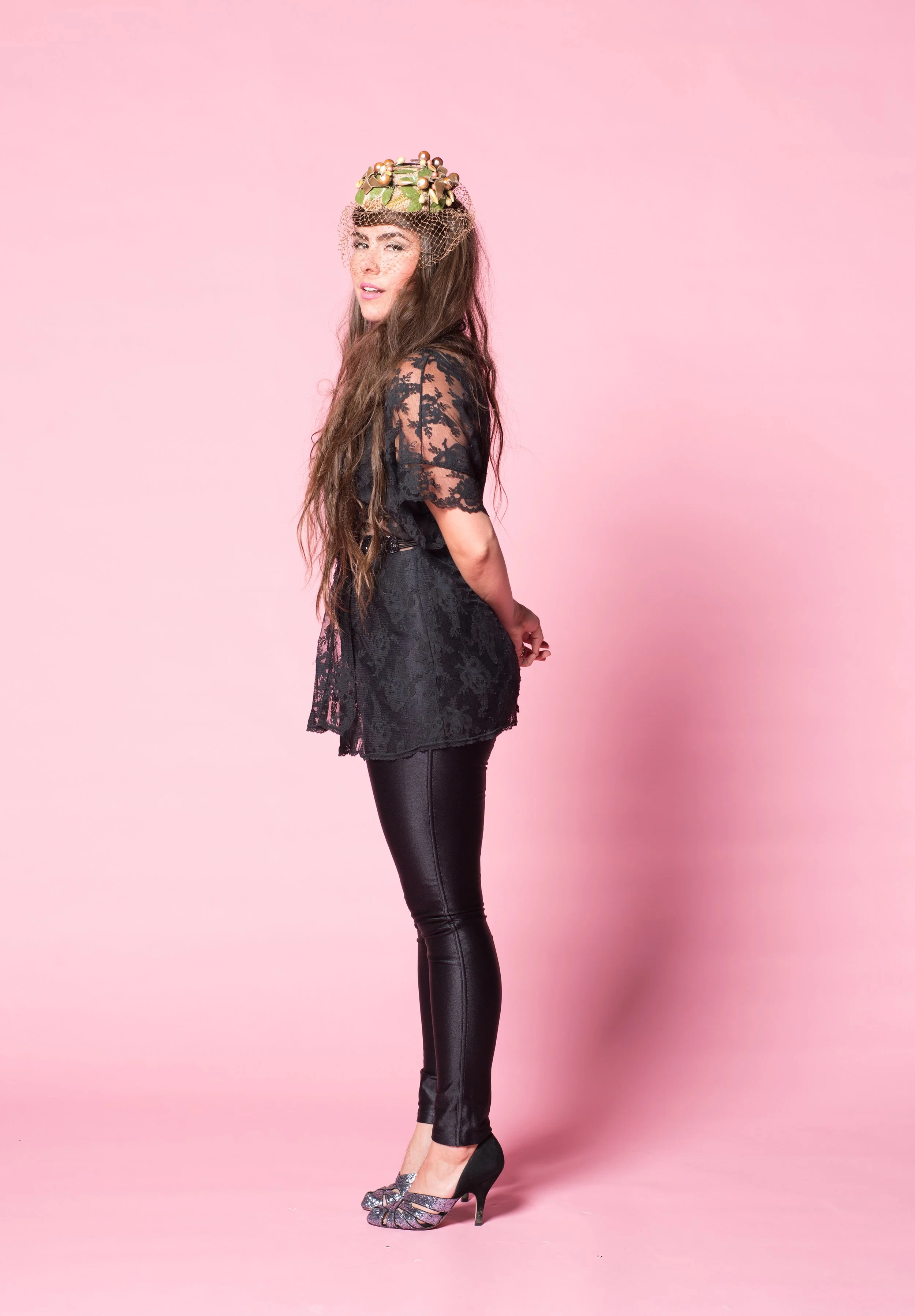 vermont musician kat wright poses for a portrait on a pink background in a photo studio