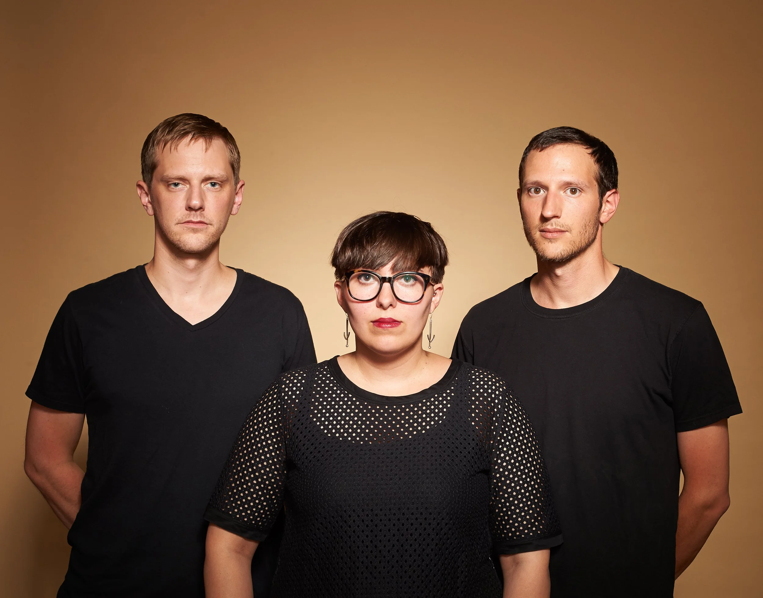 band portrait of two men and a woman all wearing black