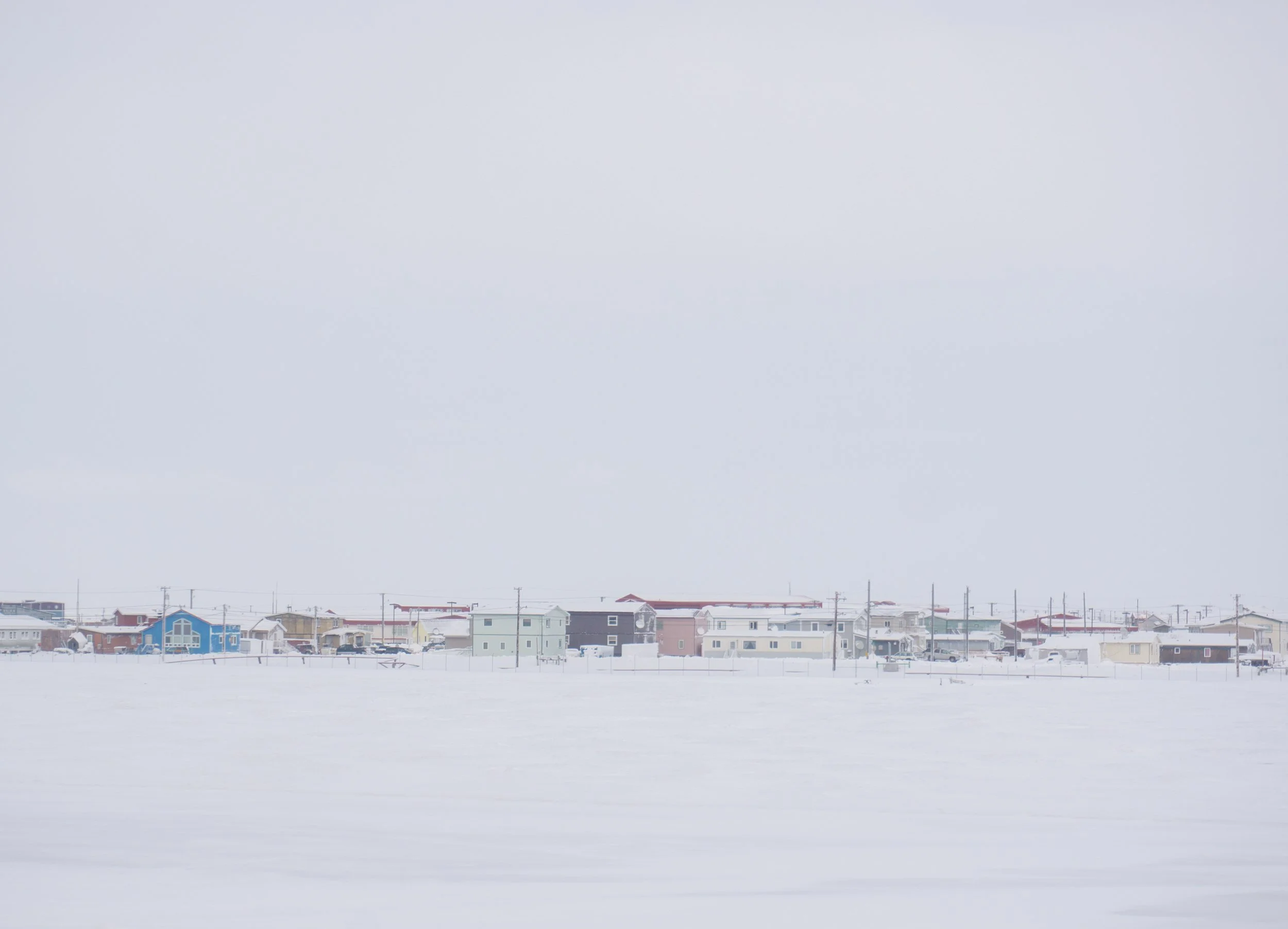 row of snow covered homes in barrow alaska during winter
