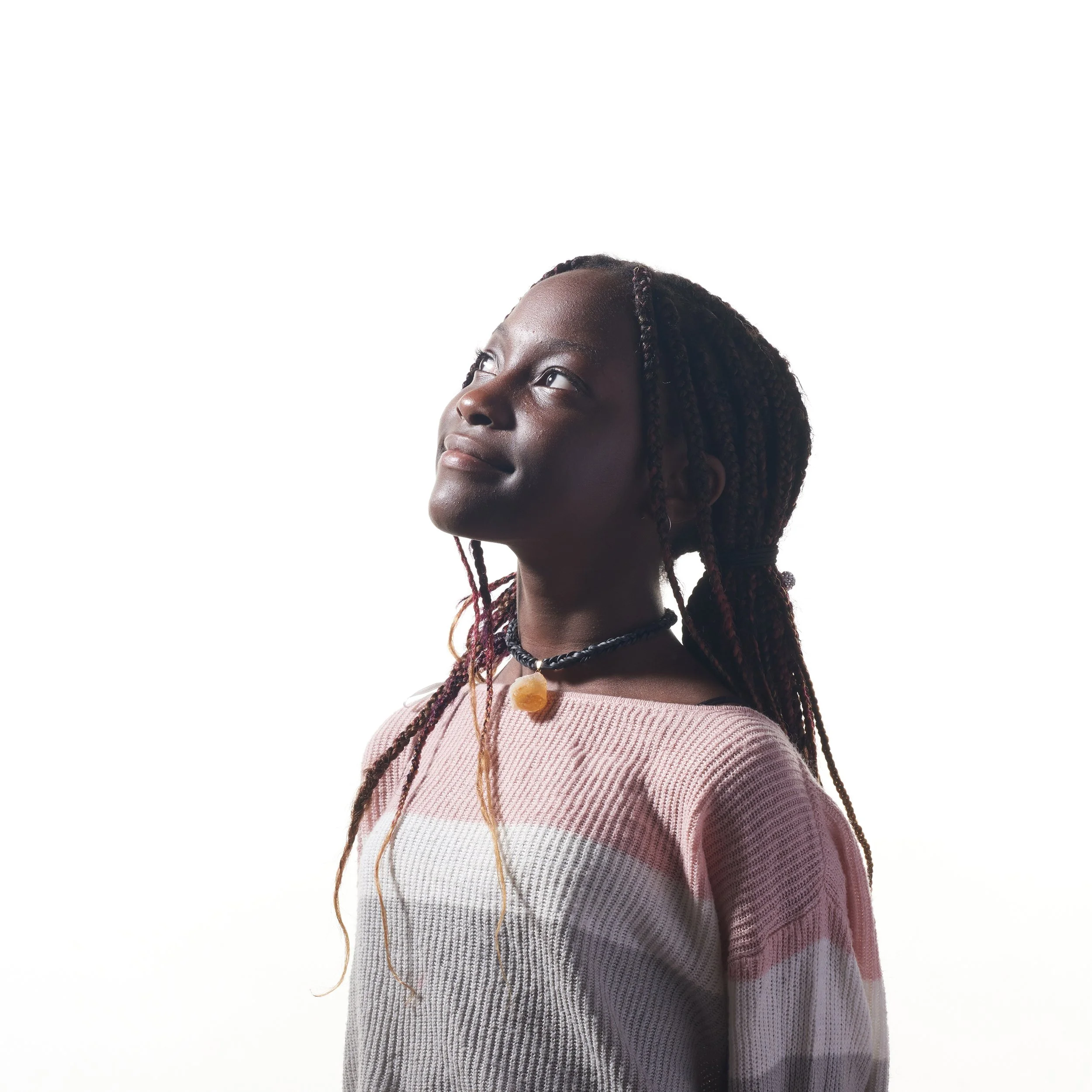 creative portrait of child smiling and looking up towards the light taken in burlingon vermont photography studio