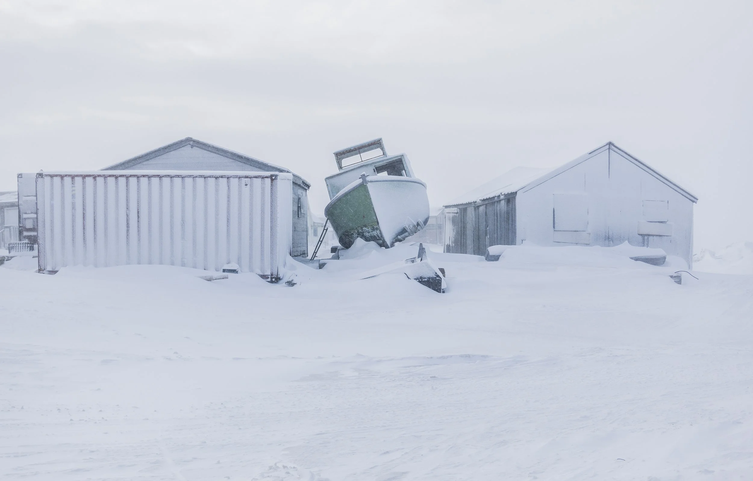 snow covered boat and buildings in barrow alaska