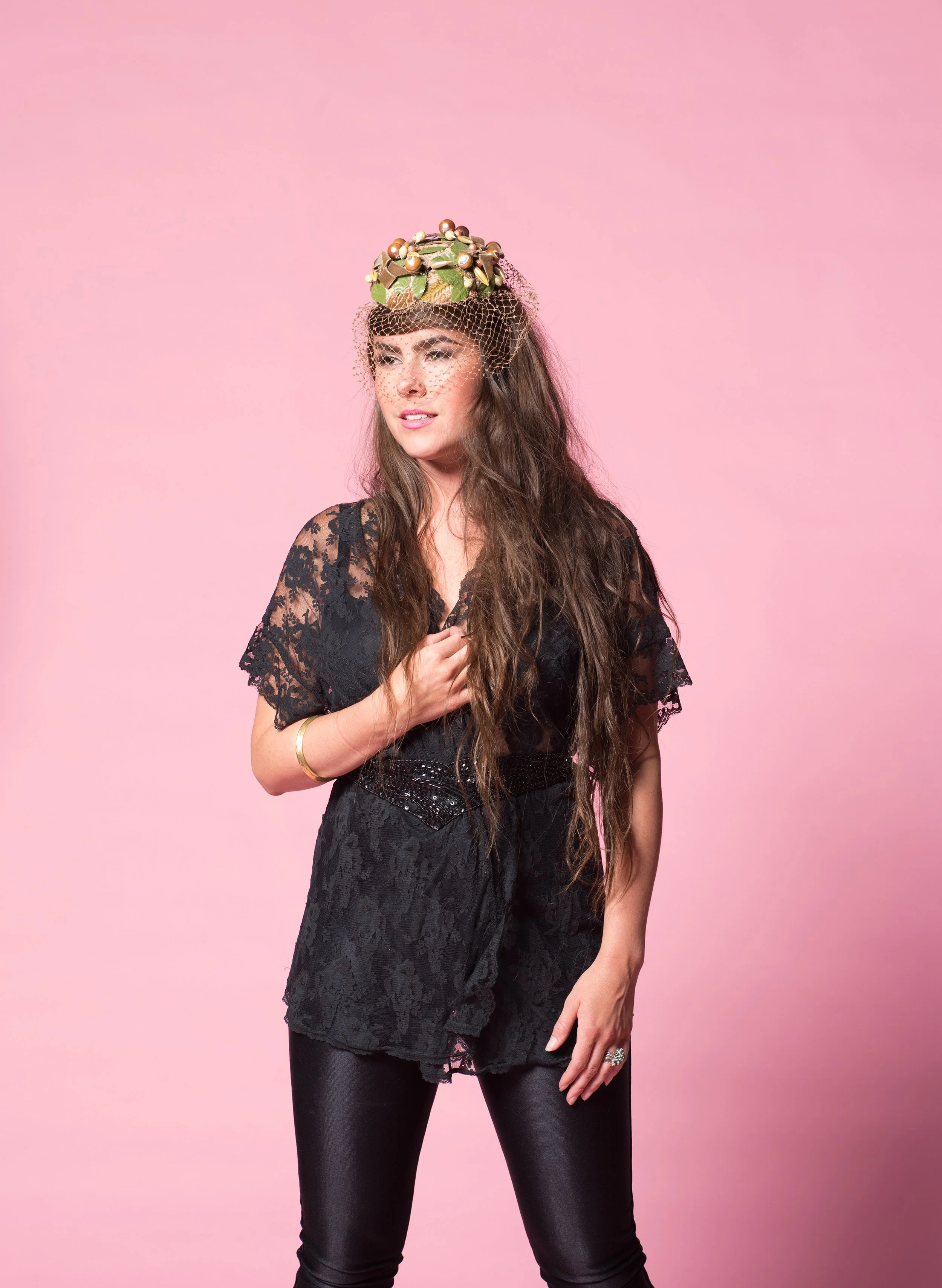 vermont musician kat wright poses in front of a pink studio background