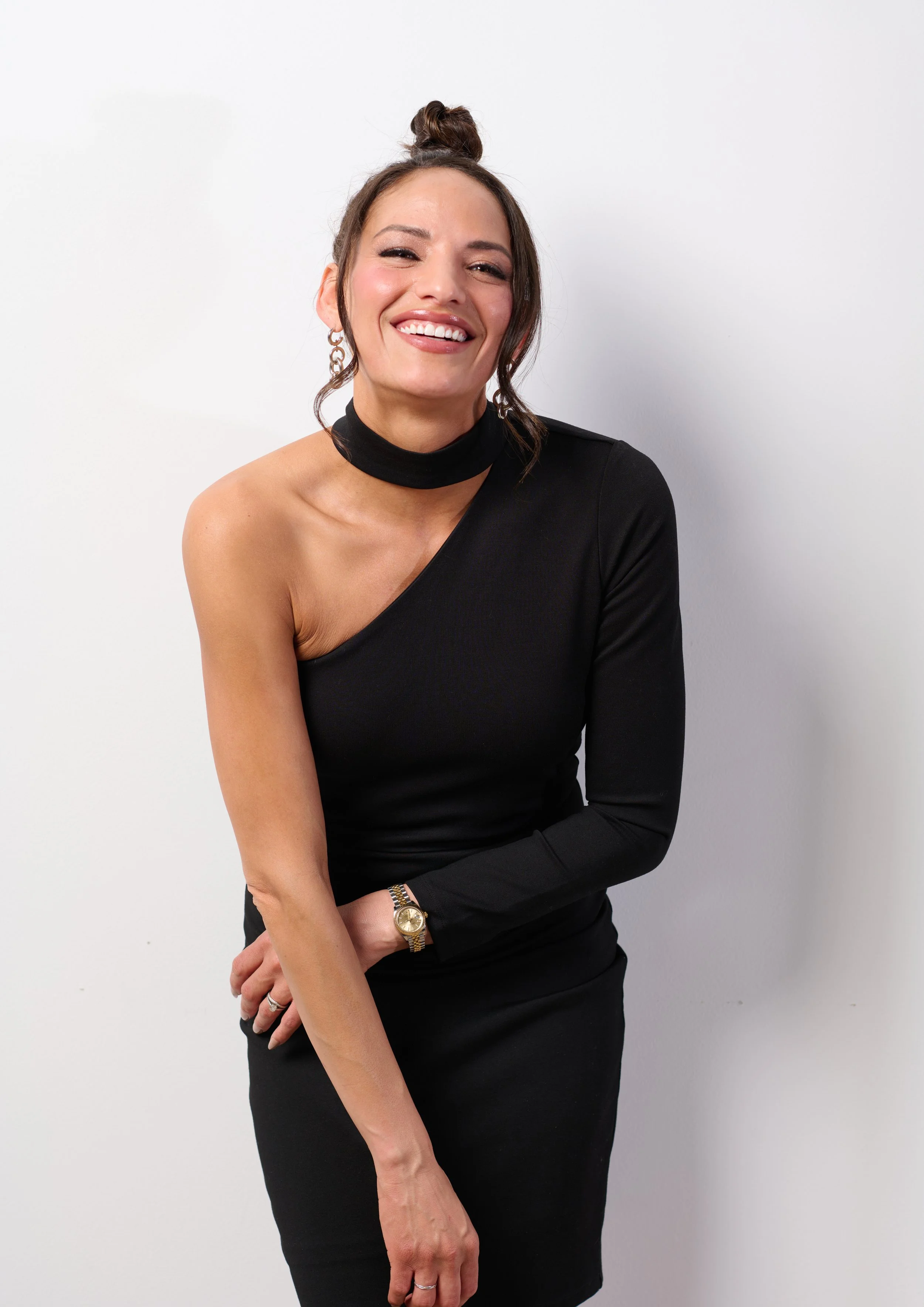 Burlington vermont fashion photographer michael heeney photographs a woman in a tight black dress against a white studio wall 
