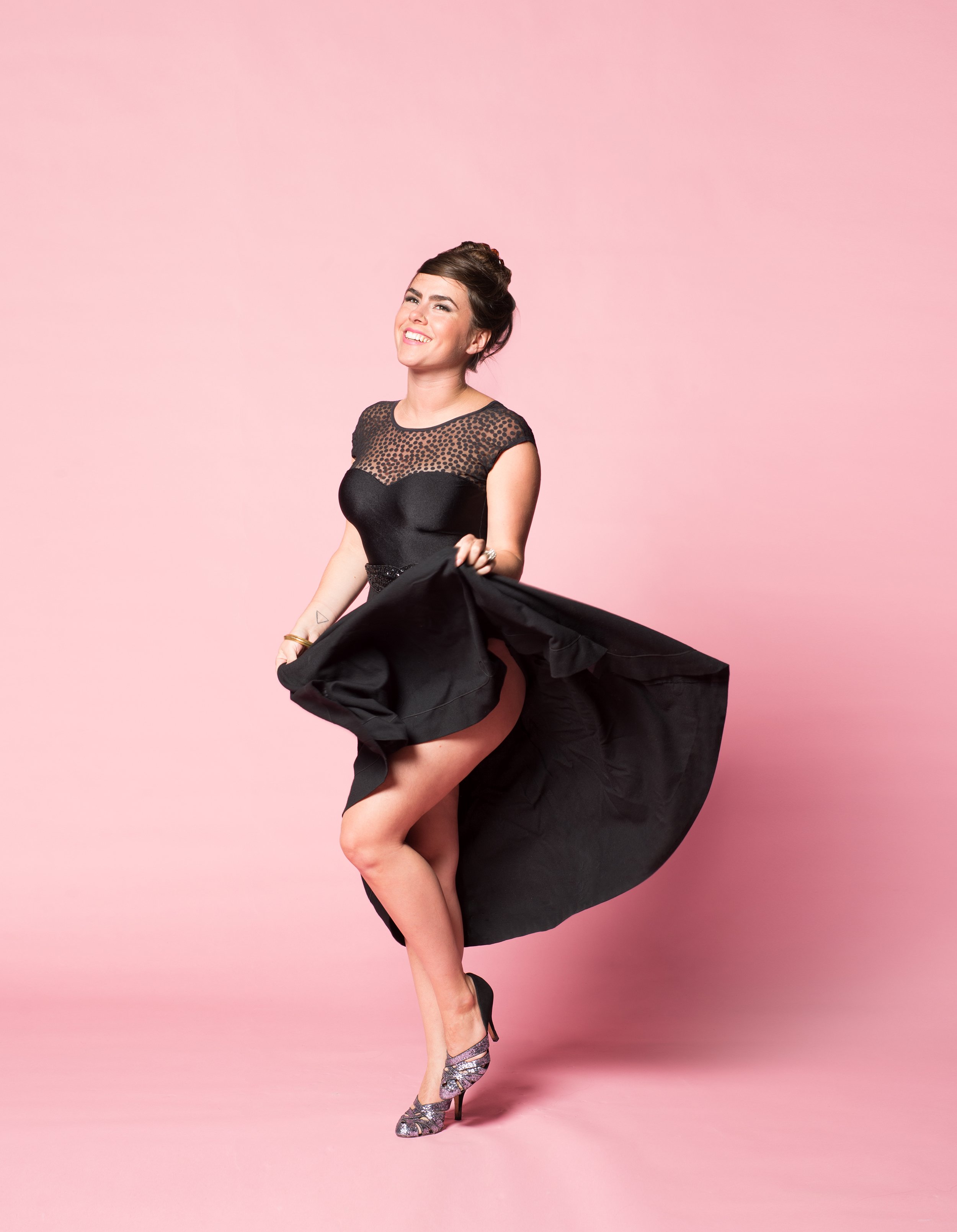 vt musician kat wright dances in black dress in front of pink background in photo studio in Burlington vermont