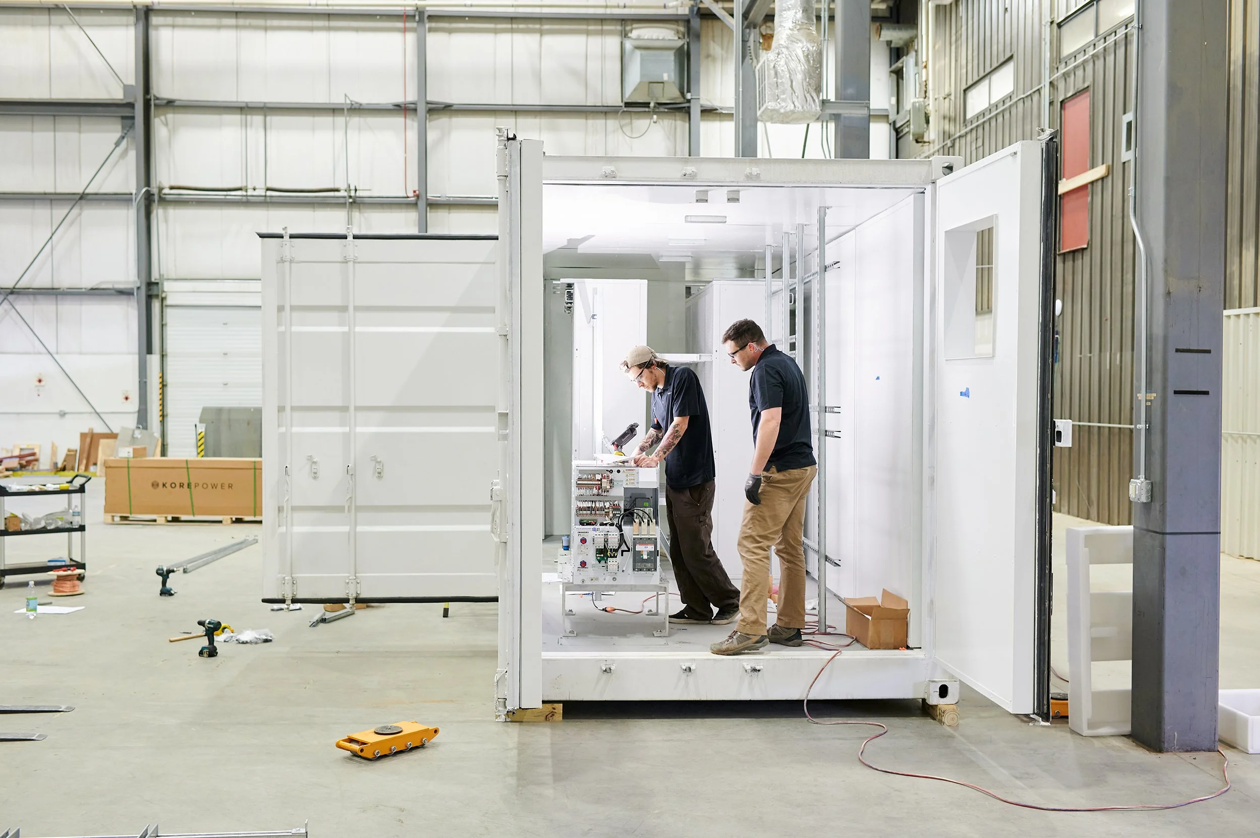 two men work on a container for high tech equipment