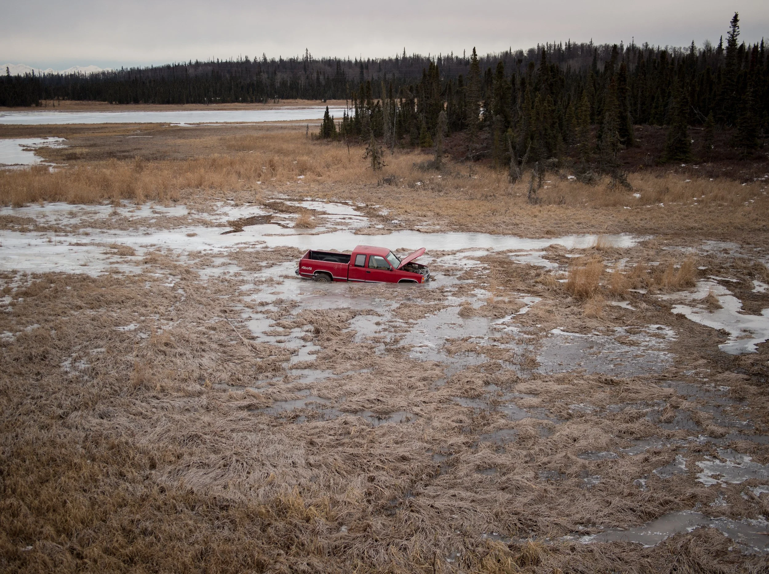 a red truck stuck in melting snow