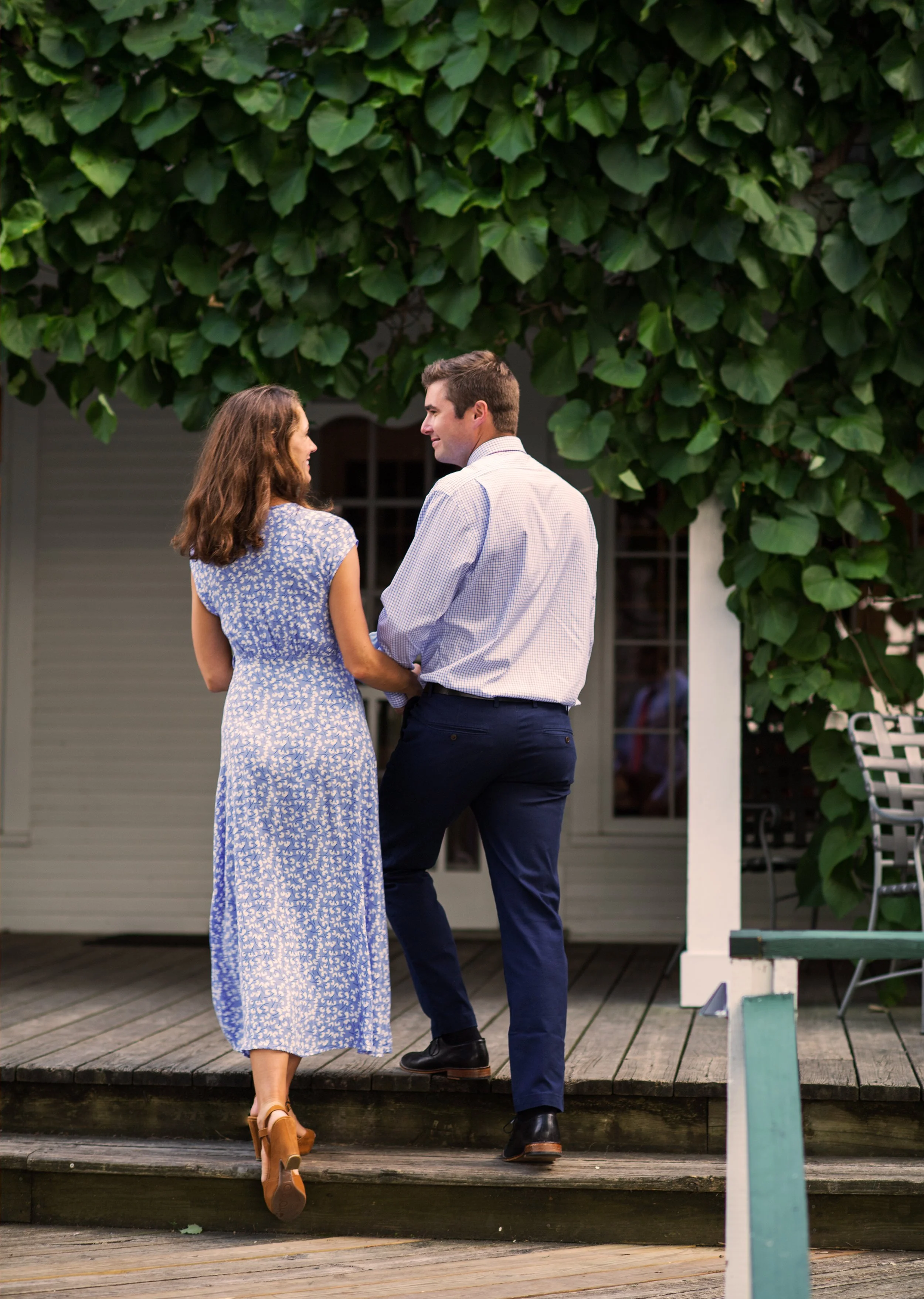 lifestyle photography of a nicely dress man and woman walk up stairs to a restaurant while smiling at each other