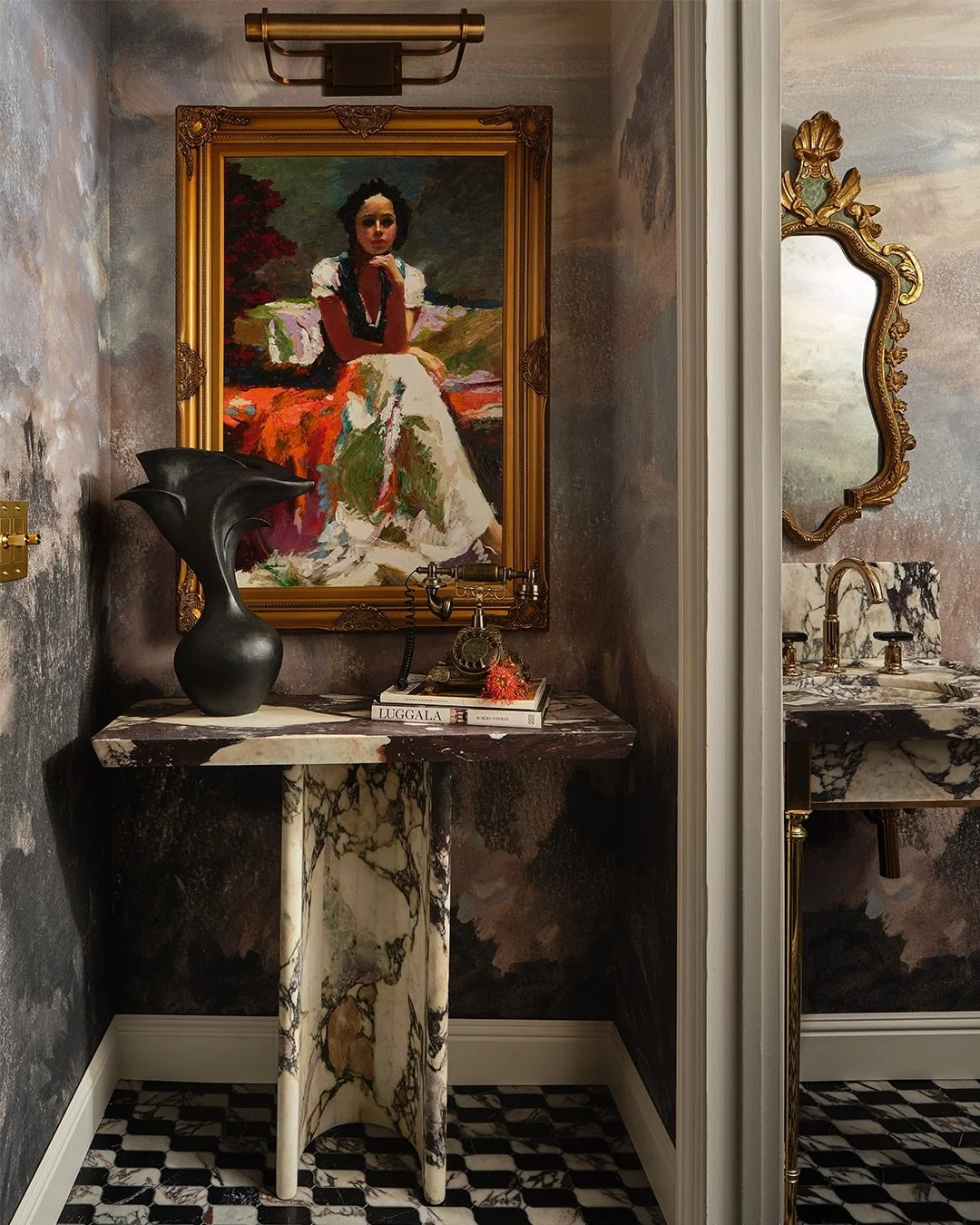 The Whispering Veil: A Powder &amp; Cloak Reverie by @rachel_scheff_design_studio

The Veiled Aether reimagines the traditional pwder and cloak room as an ethereal passage between past and present. A hand-painted mural washes the walls in moody water