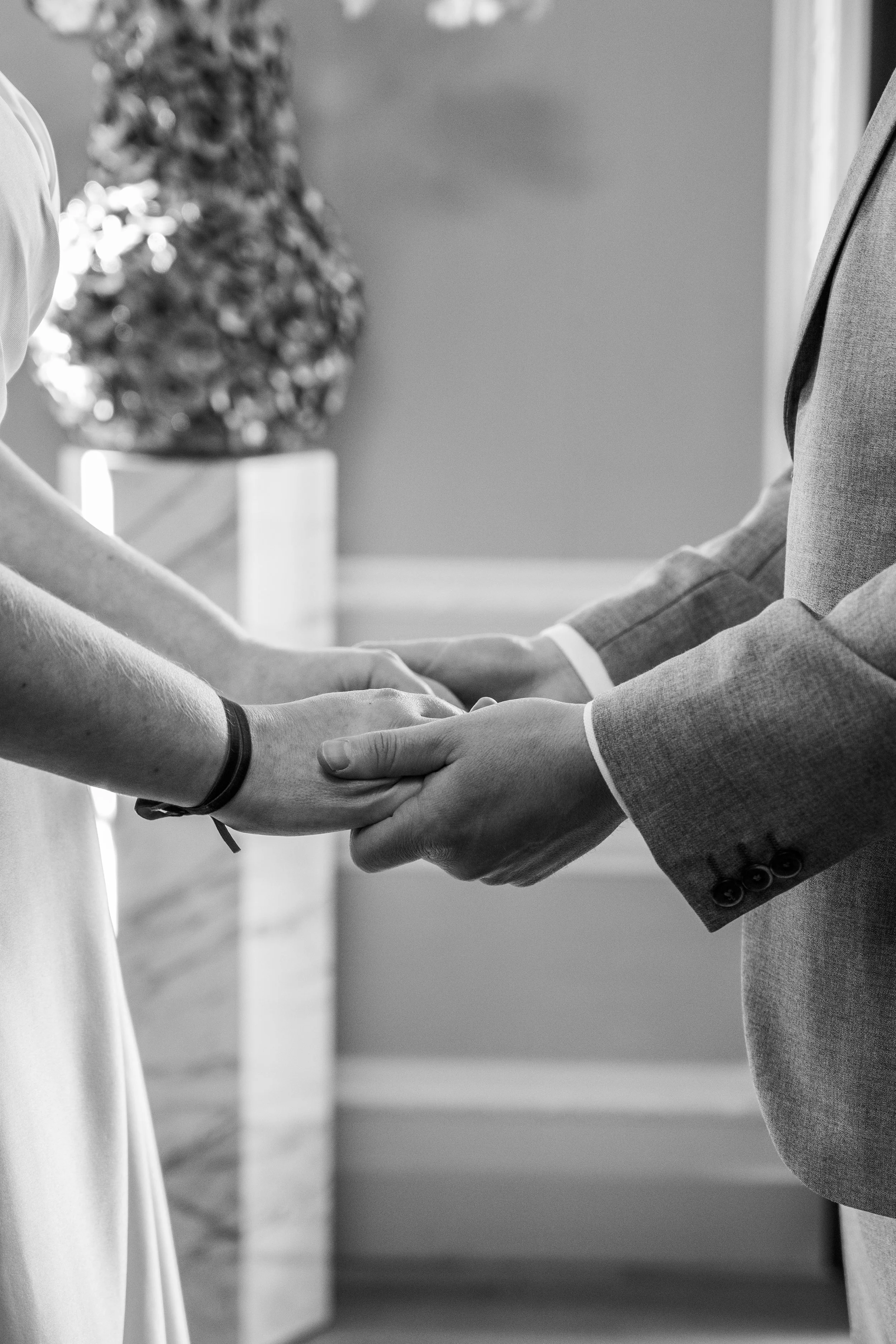 Twee mensen houden elkaars handen vast tijdens een huwelijksceremonie.
