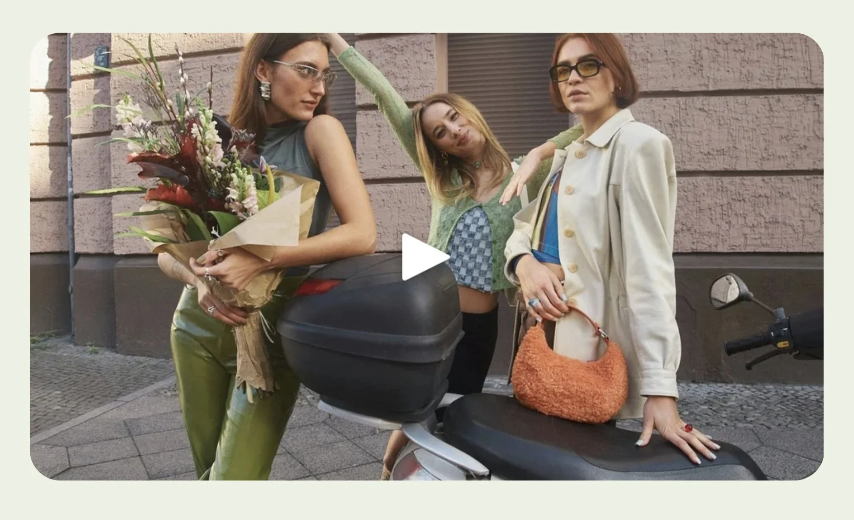 Video with rounded corners and a featured image of 3 young women with a scooter.