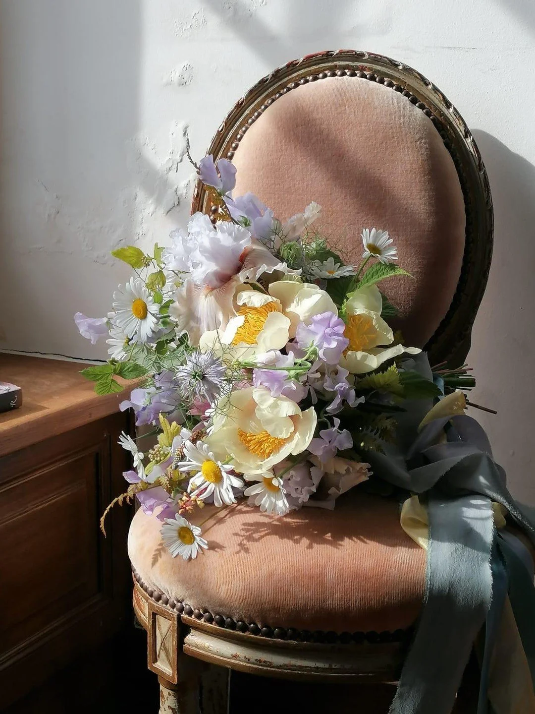 Dreamy flowers perched on a dreamy chair, in a dreamy castle, bathed in dreamy light.

This exquisite May bouquet from my trip to @fleuropean in 2024 still tugs at my heart. The buttery Claire de Lune peonies, alongside pale lilac sweetpea and nigell