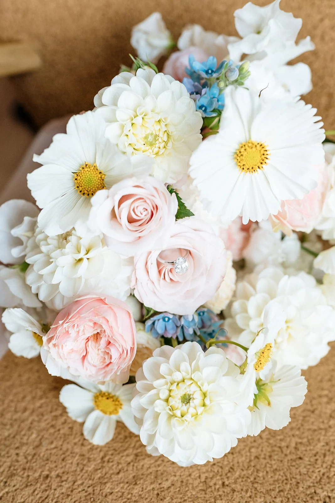 pastel coloured flowers bridal bouquet with an engagement ring