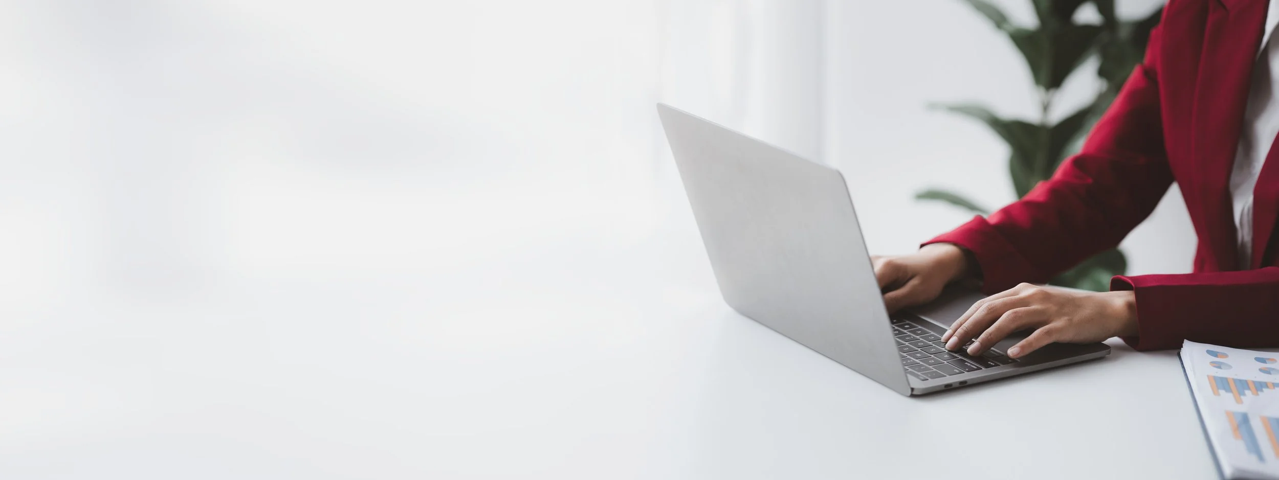 Woman typing on a laptop, symbolizing exploring practical gut health tips and blog posts.