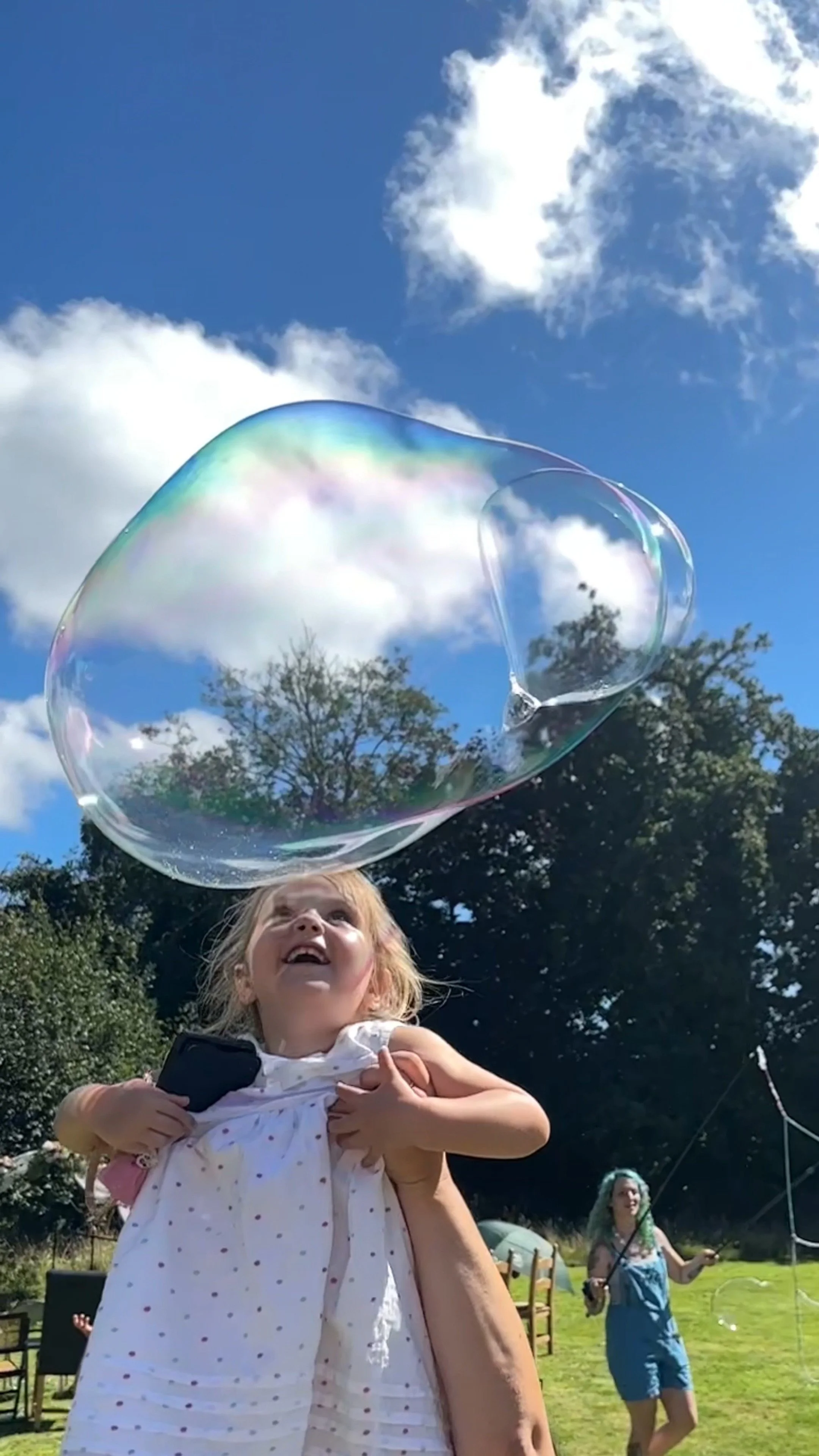 Child popping large bubble with head
