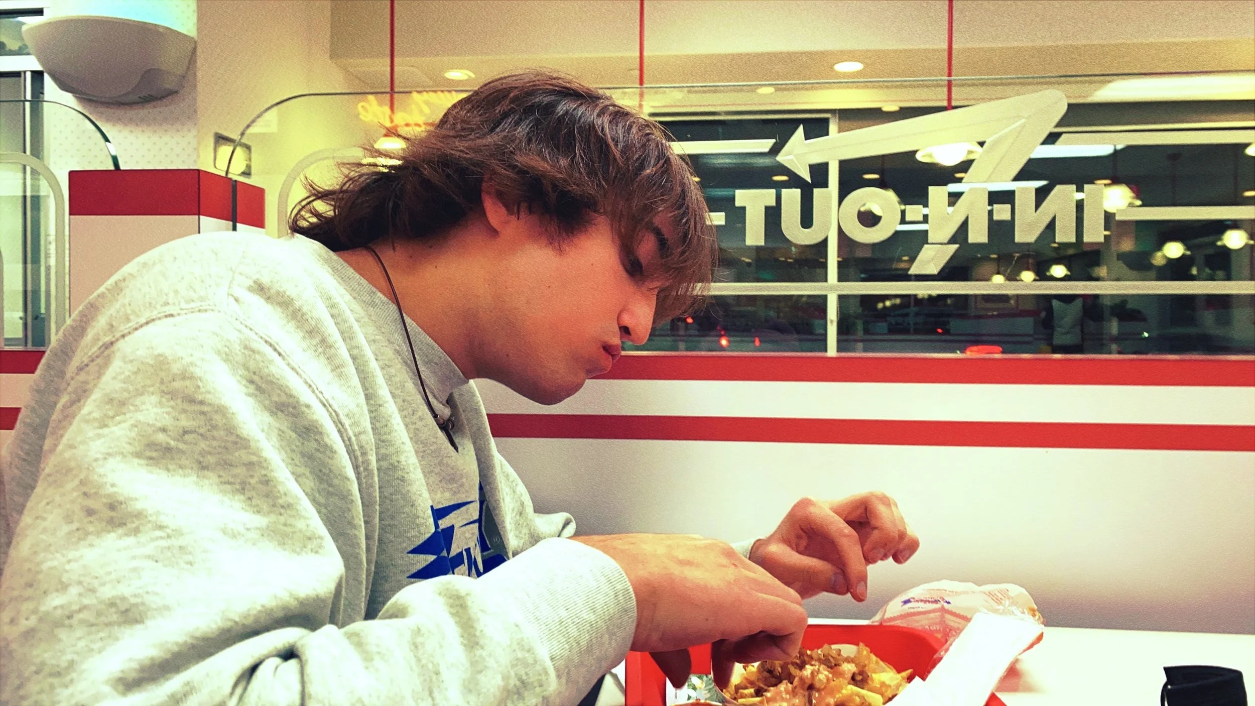 Micah Taylor eating at an In-N-Out Burger restaurant. By Christopher Clucas.