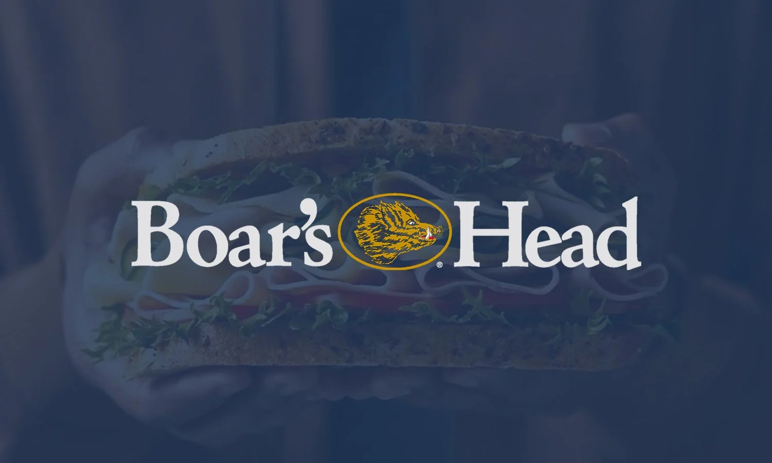 A sandwich with lettuce, tomato, and meat inside a hoagie bun, with the text 'Boar's Head' and the 'Boar's Head' logo overlaid.