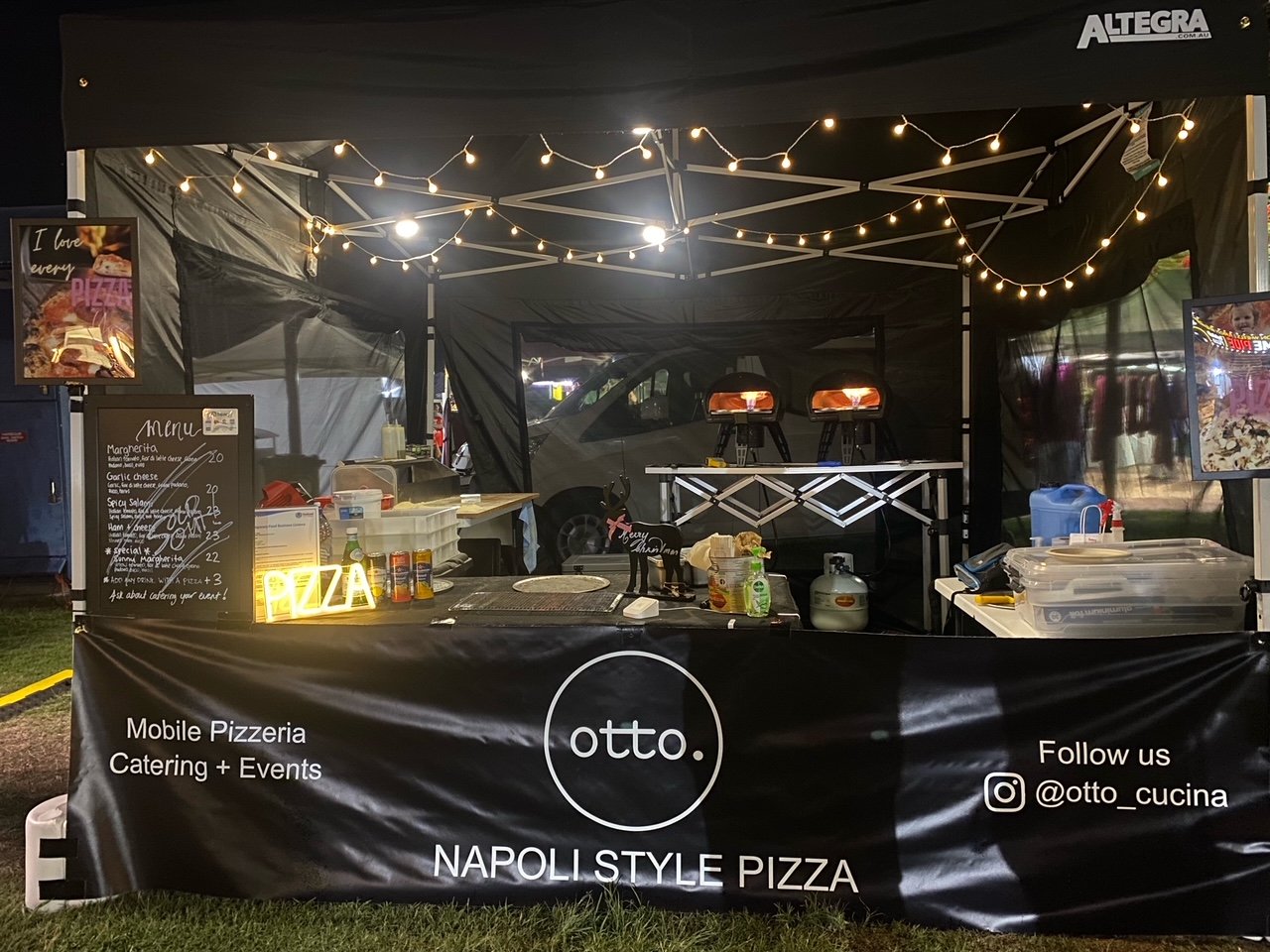 Outdoor pizza stall with "otto" branding, offering Napoli-style pizza. Includes a menu board, string lights, pizza ovens, and a neon "PIZZA" sign. Social media handle "@otto_cucina" displayed.