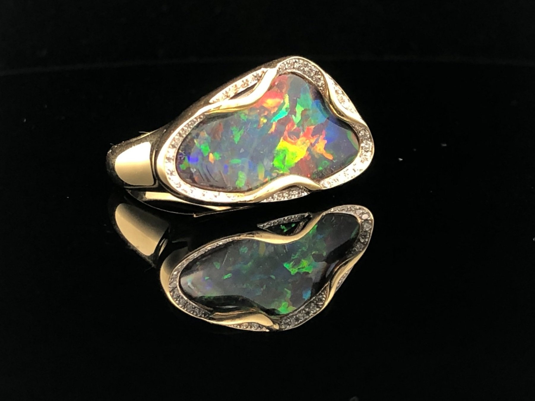 Side on view of an 18K Yellow Gold Queensland Boulder Opal and Diamond Ring