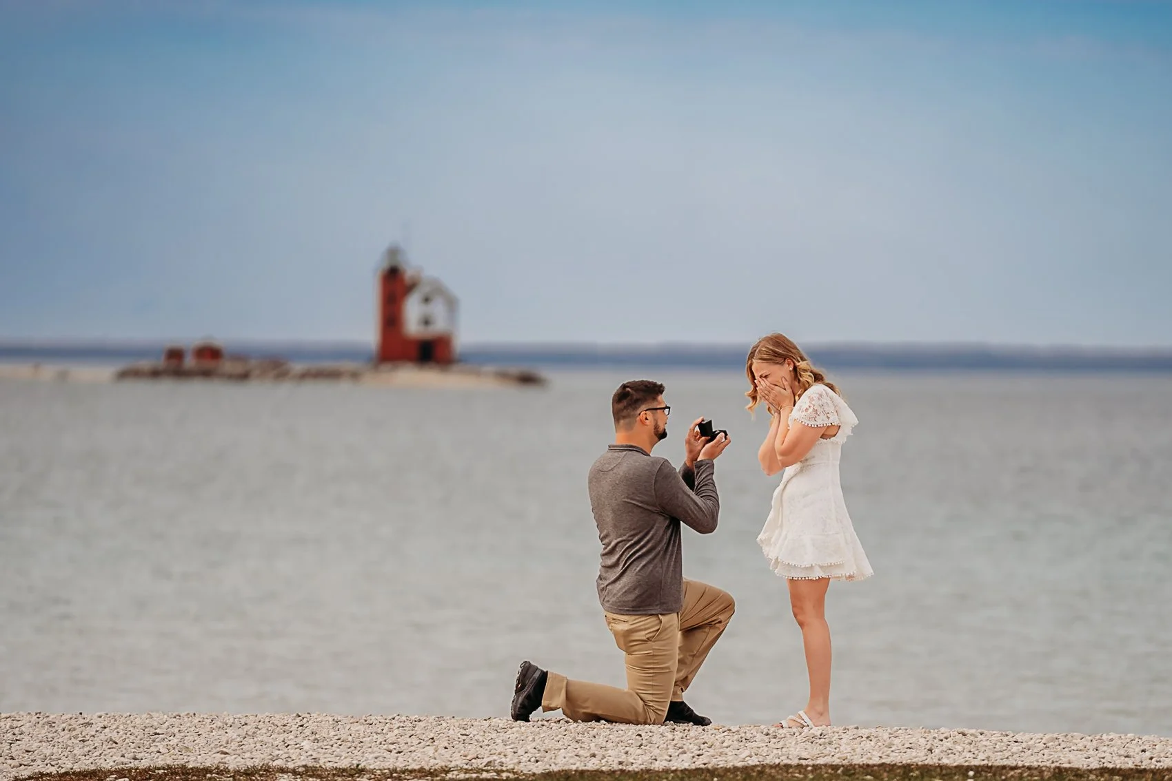 intimate proposal at windermere point on mackinac island with round island lighthouse in the background