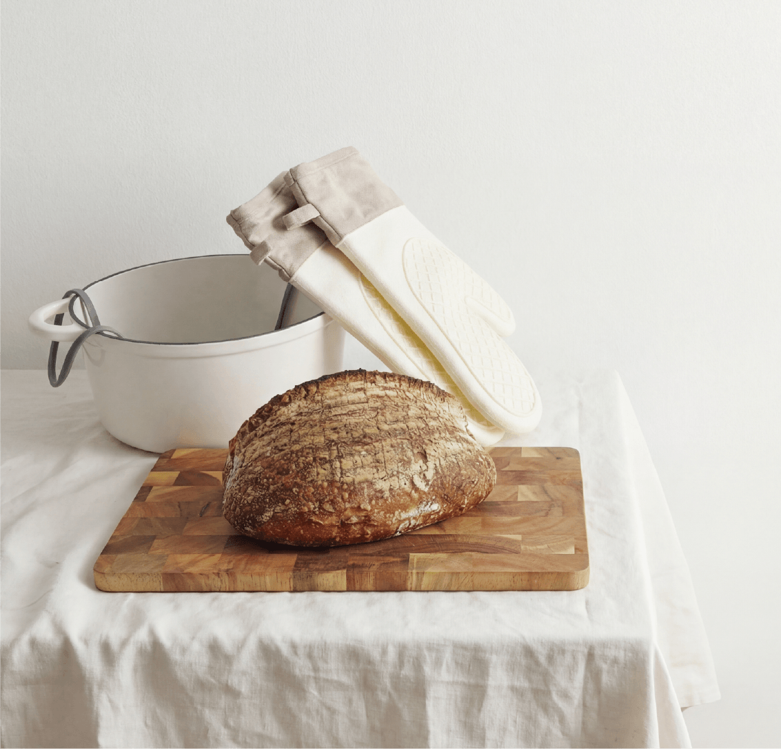 Baked sourdough loaf with essential kitchen tools ready to serve