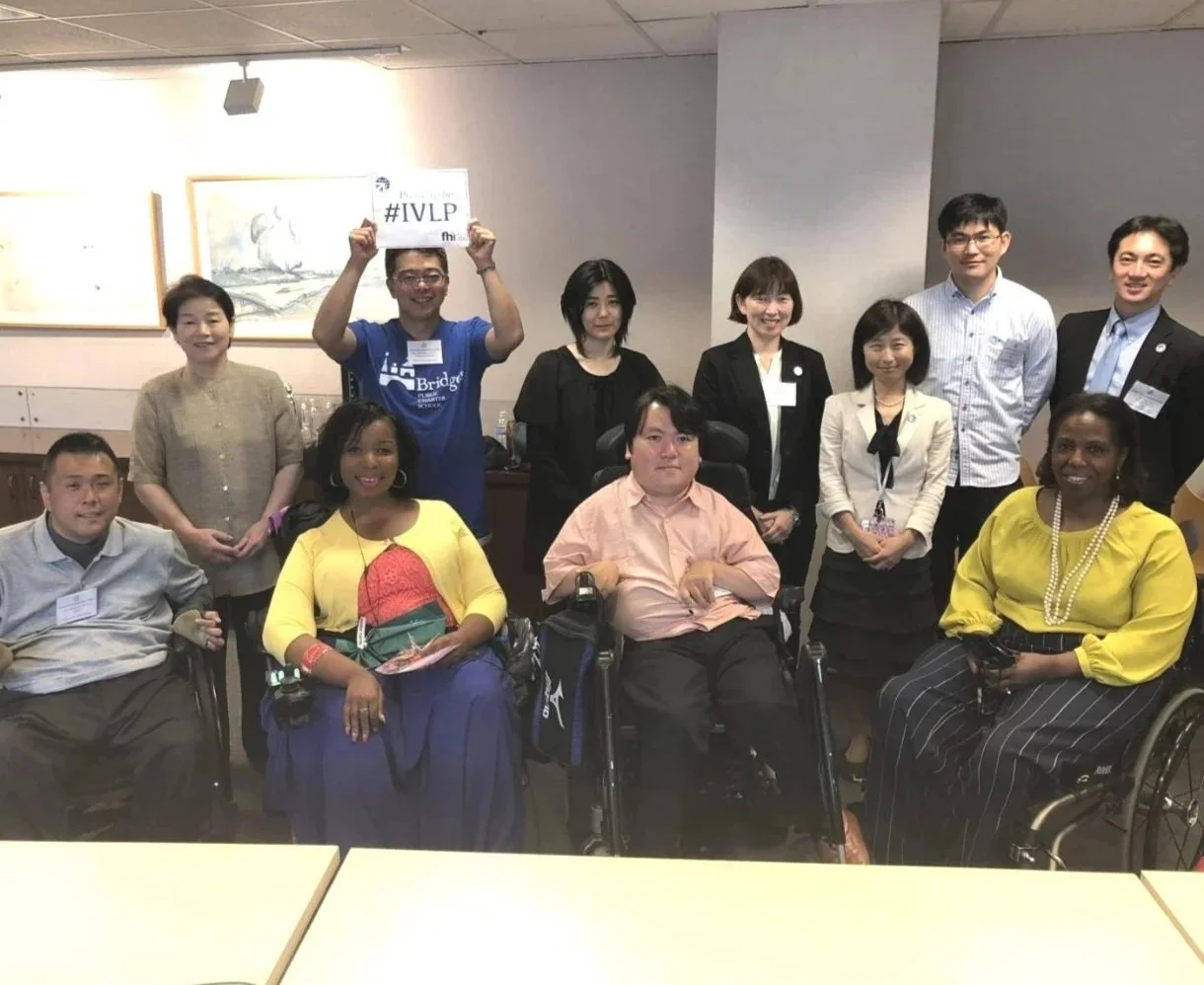 A diverse group of individuals in wheelchairs holding signs, advocating for accessibility and inclusion.